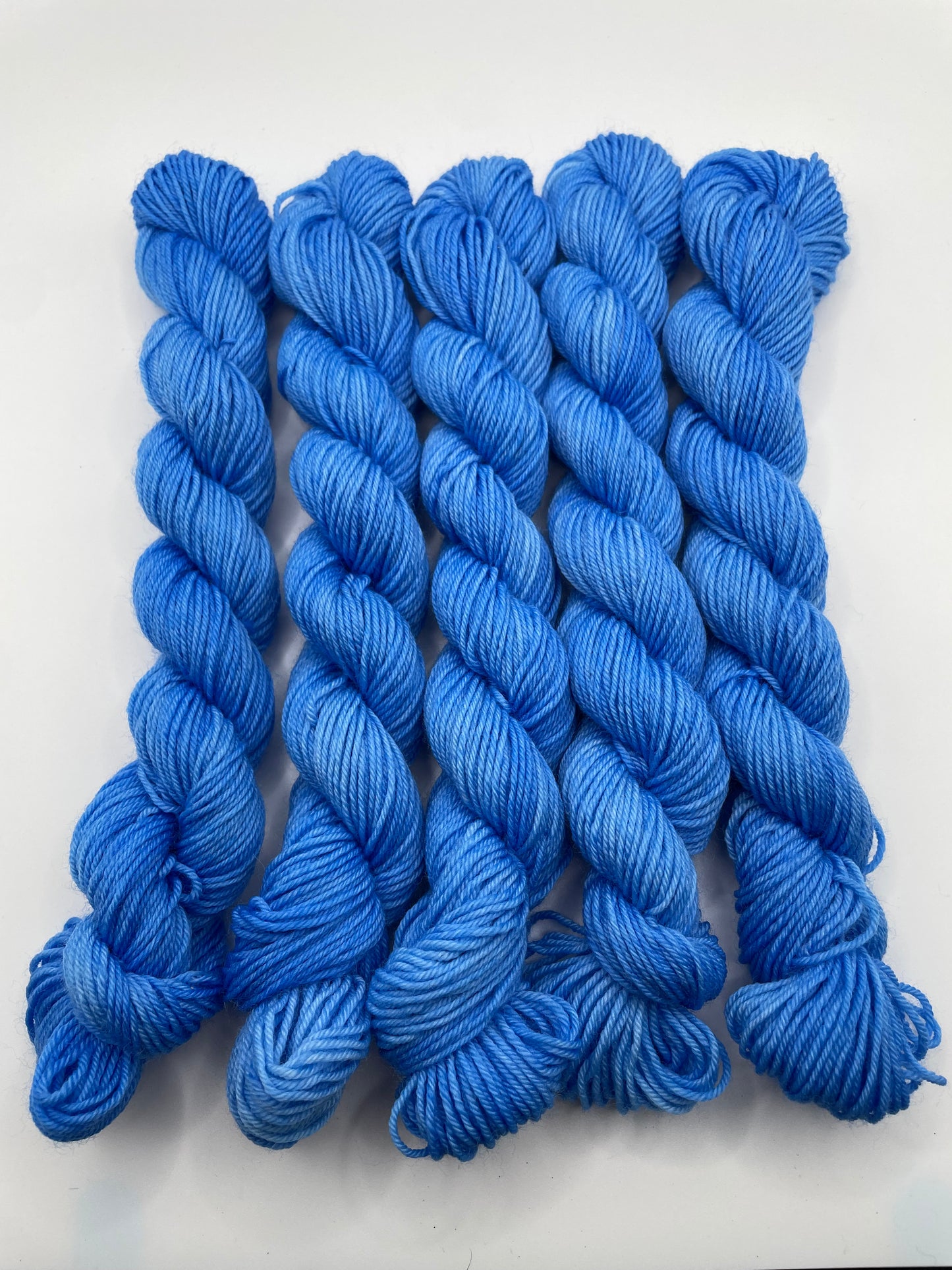 Blue yarn mini skeins on a white background