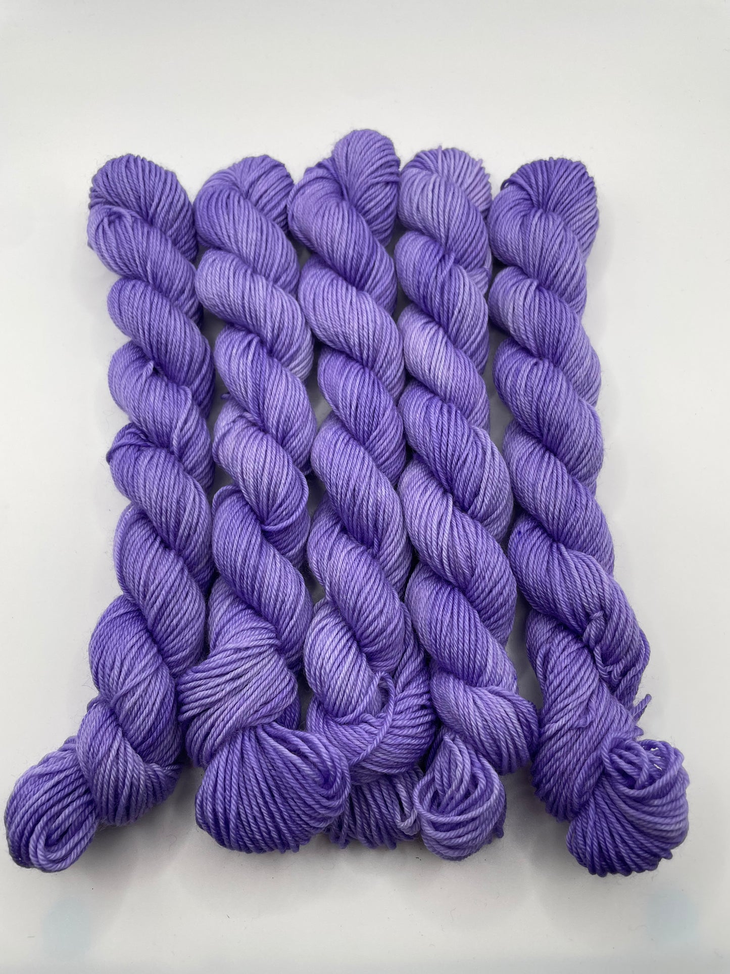 Purple yarn mini skeins on a white background