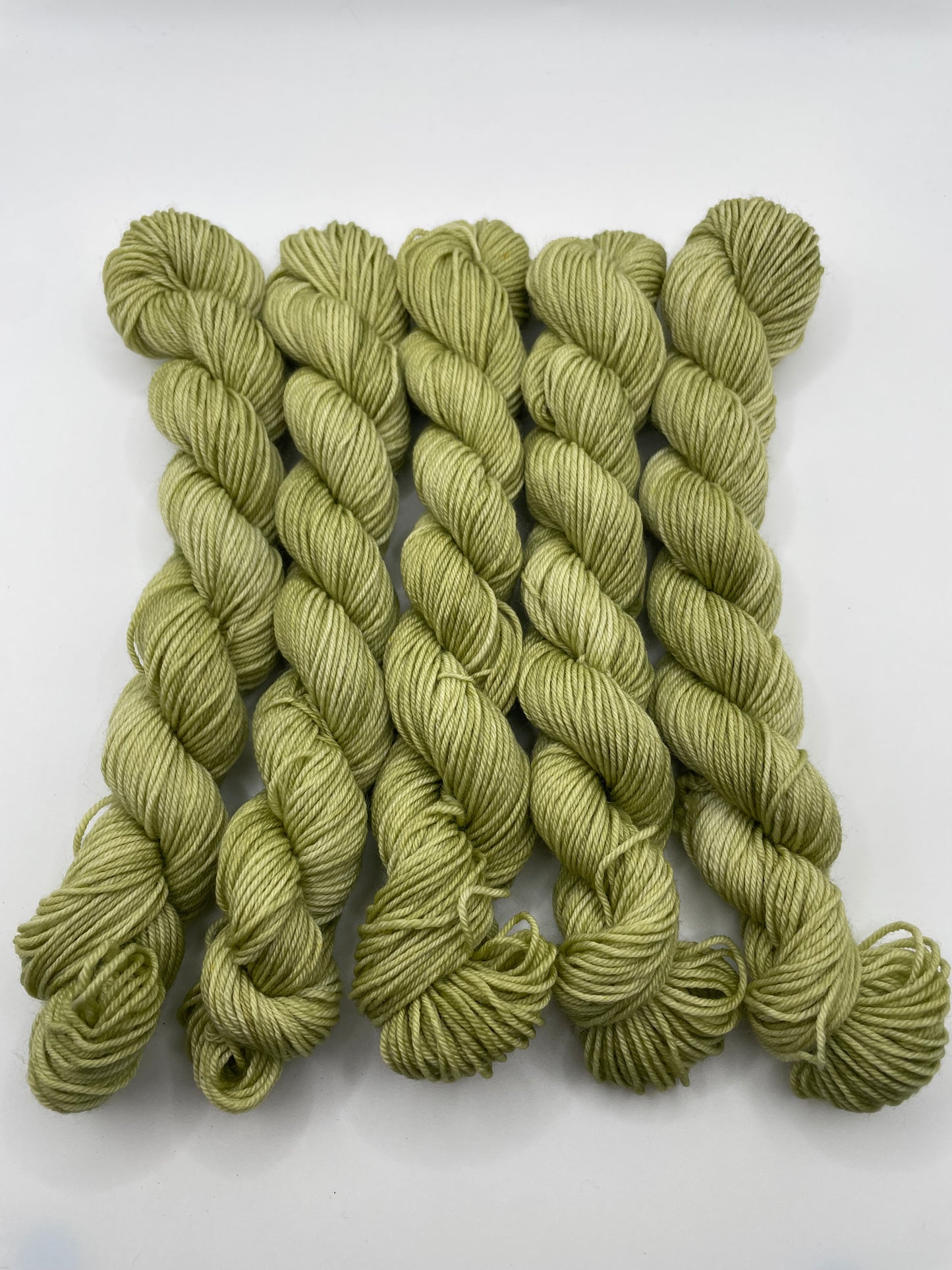 Green yarn mini skeins on a white background