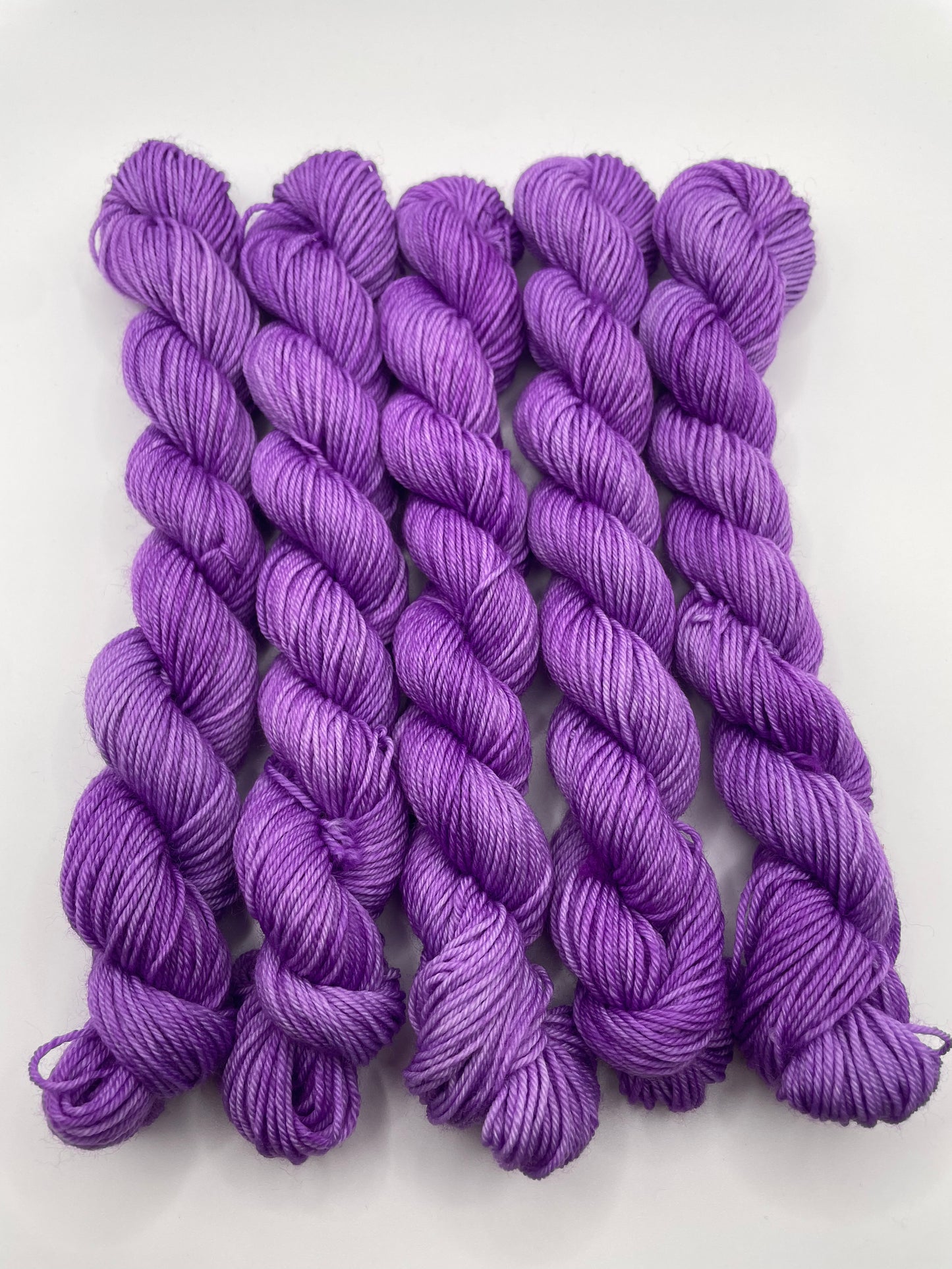 Purple yarn mini skeins on a white background