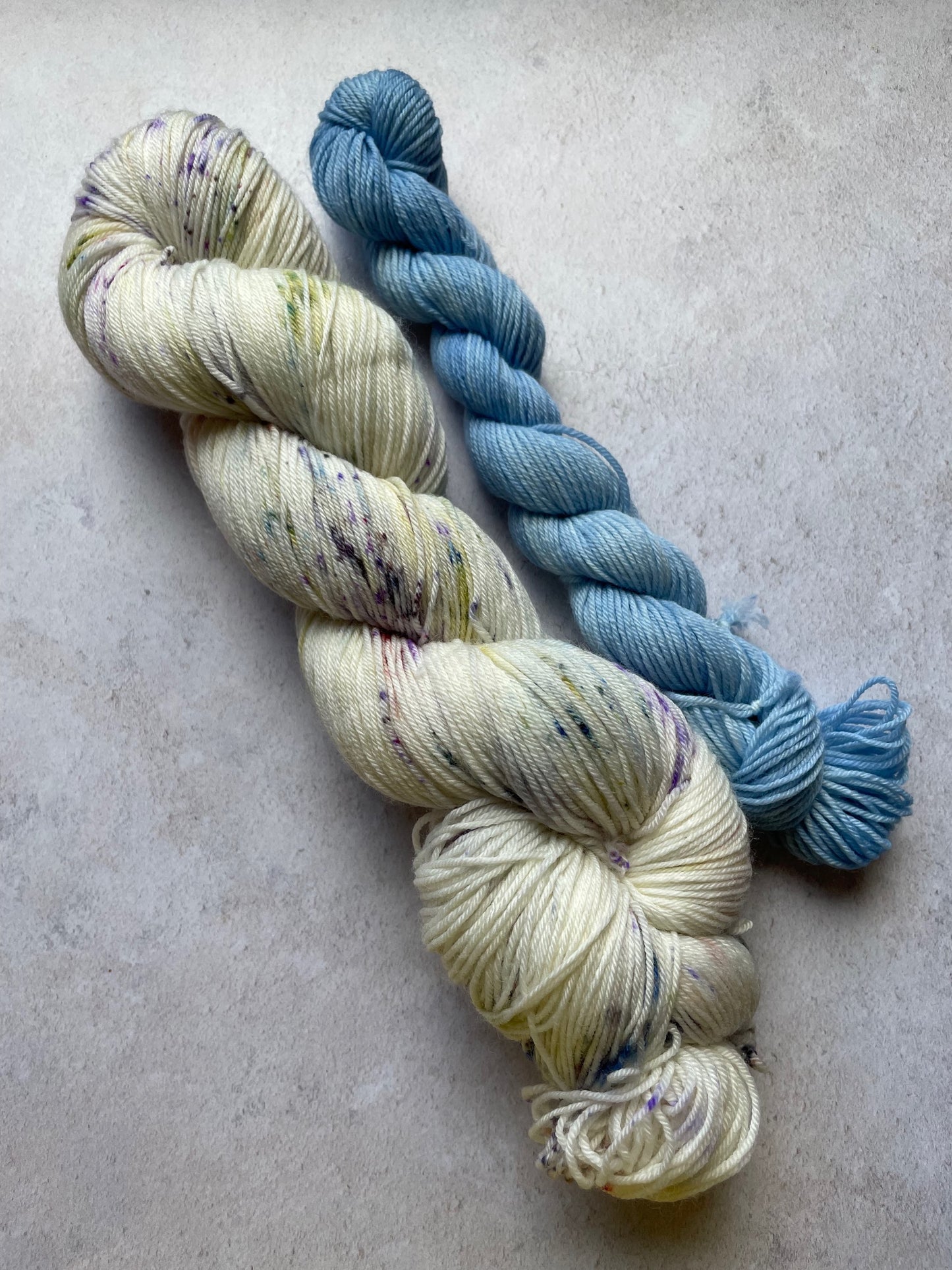 120g sock set with lightly speckled main skein and light blue mini skein