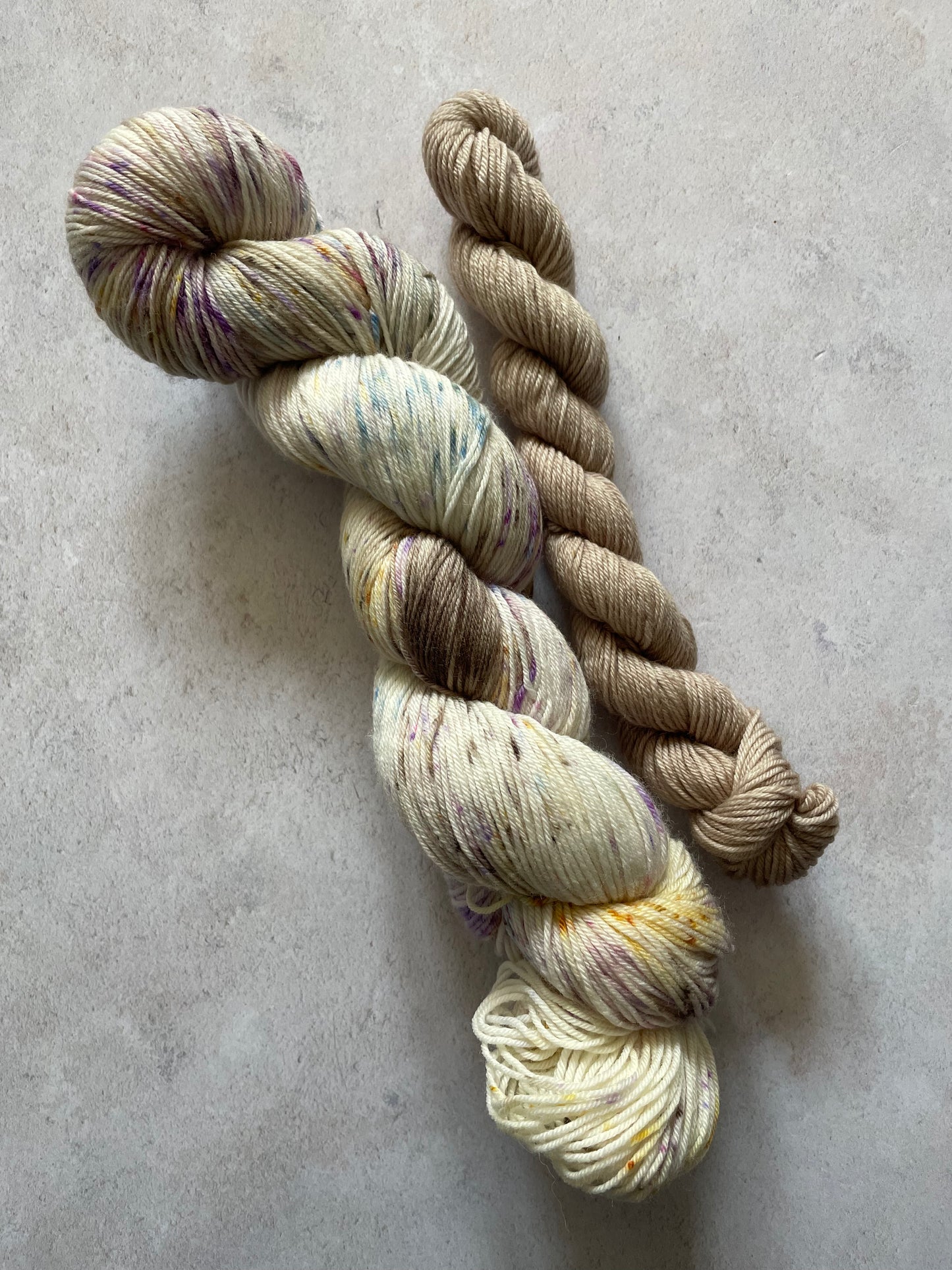 120g sock set with brown yellow blue and lilac speckled main skein and brown mini skein