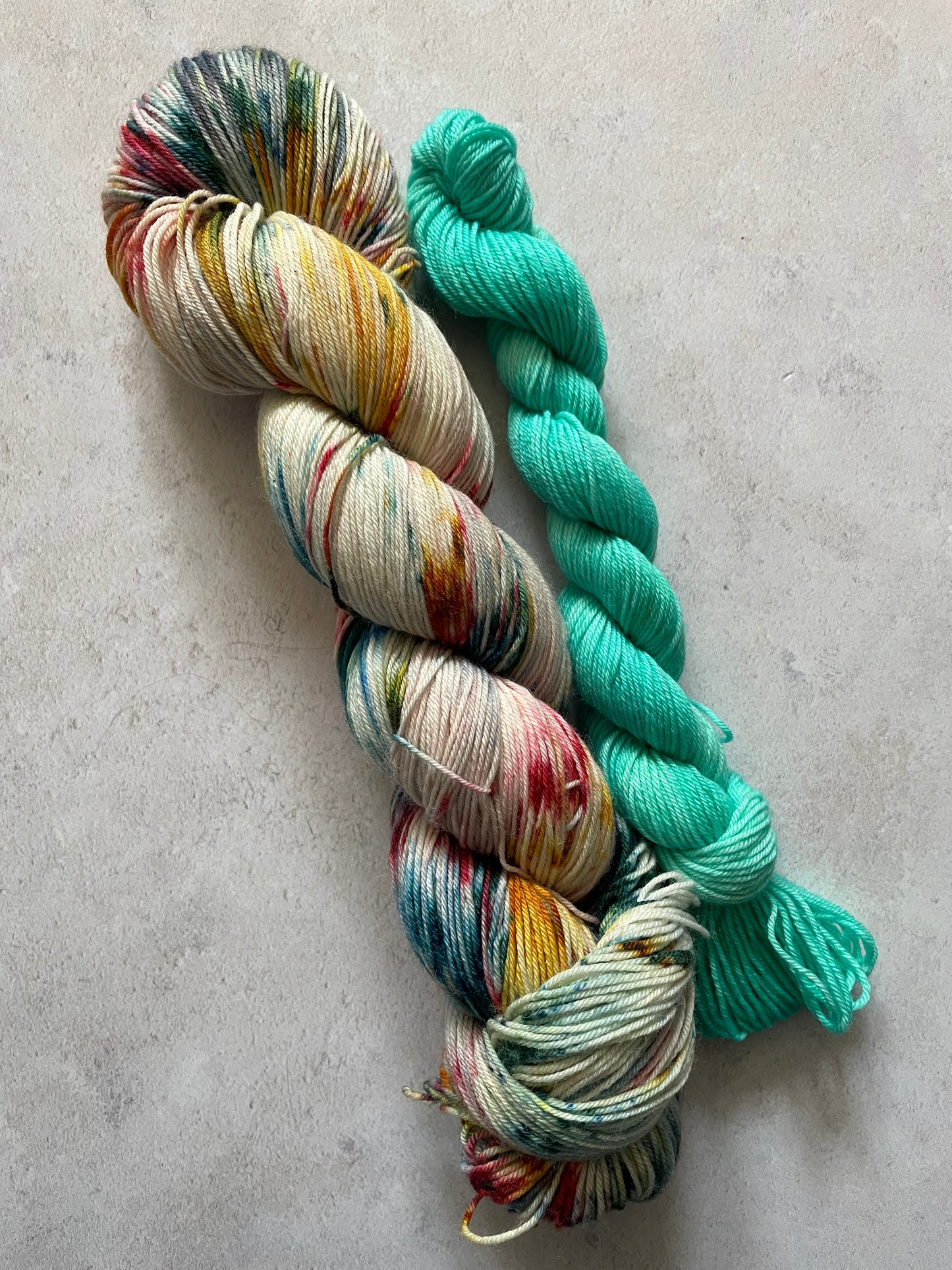 120g sock set with red yellow and teal speckled main skein and teal mini skein