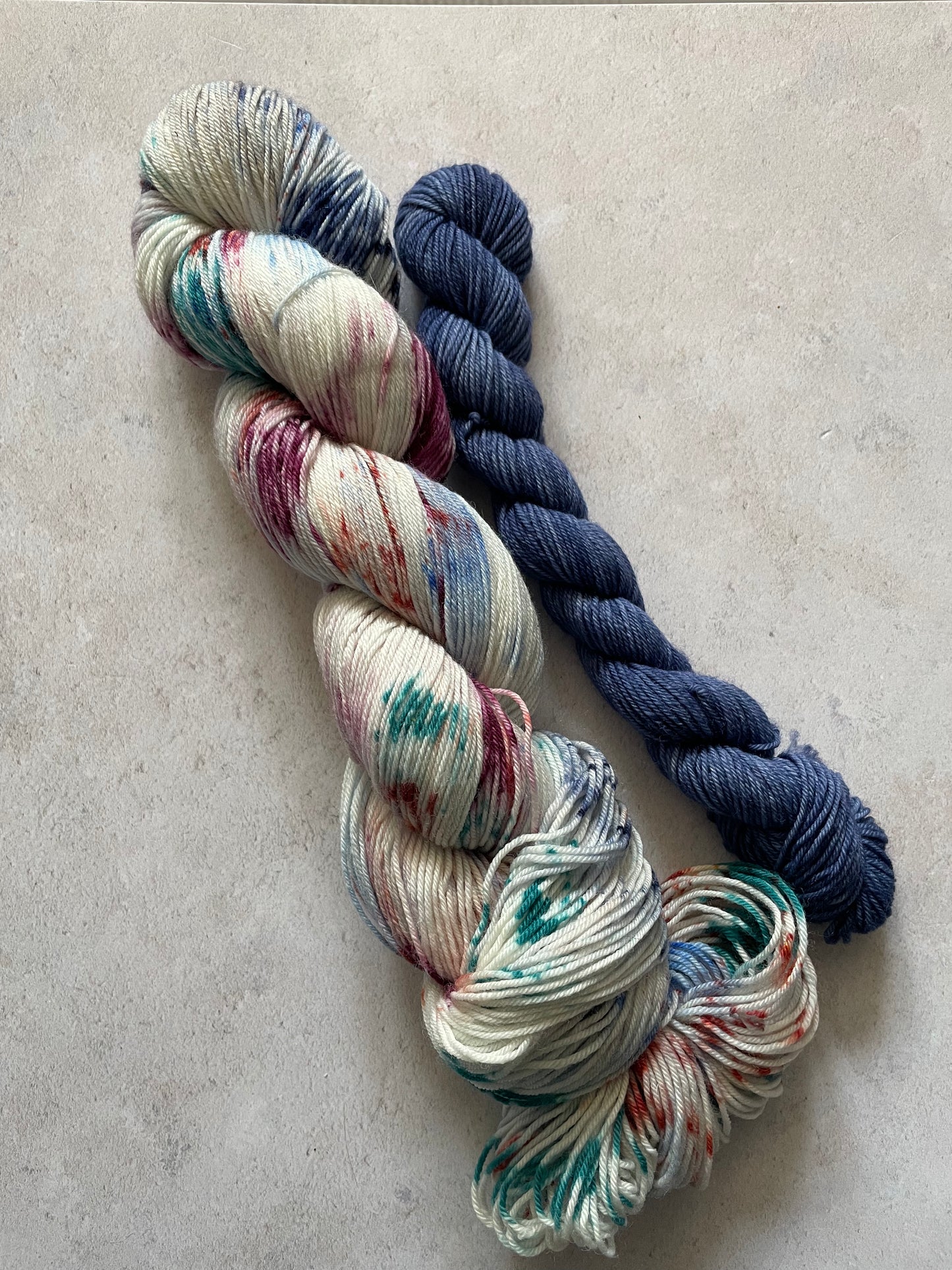 120g sock set with burgundy rust blue and teal speckled main skein and blue mini skein