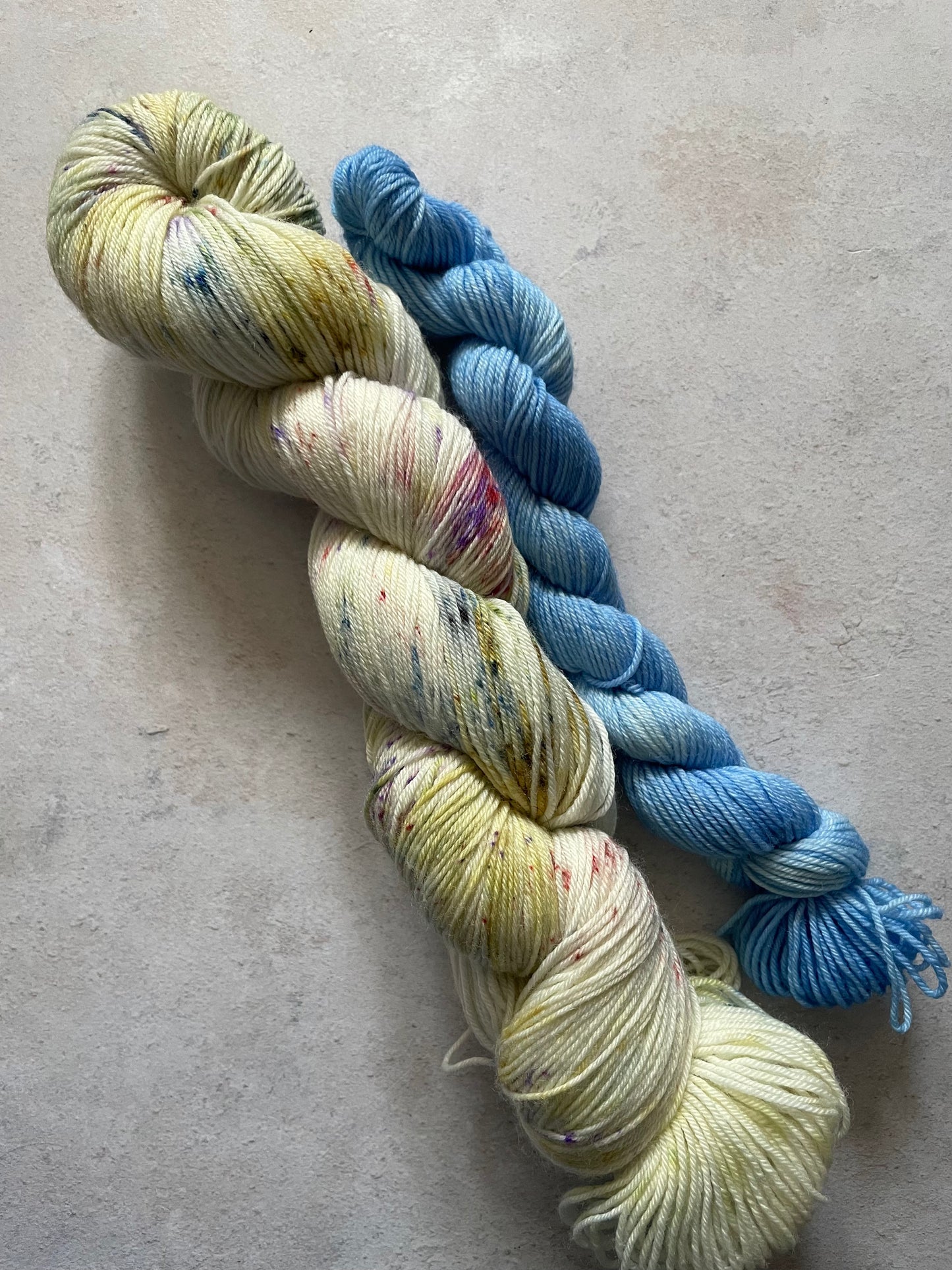 120g sock set with lightly speckled main skein and blue mini skein