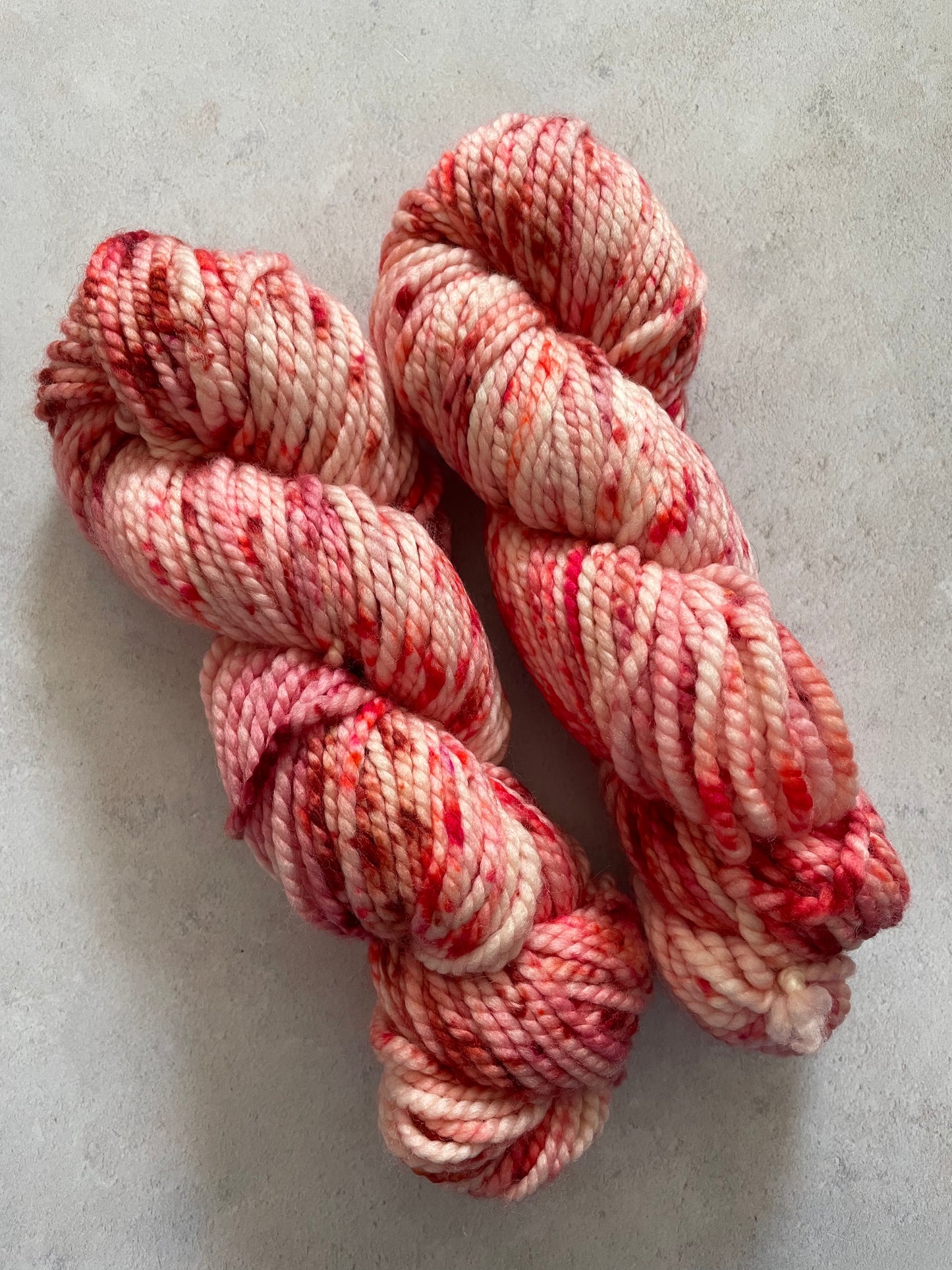 Chunky yarn skeins speckled with different shades of red