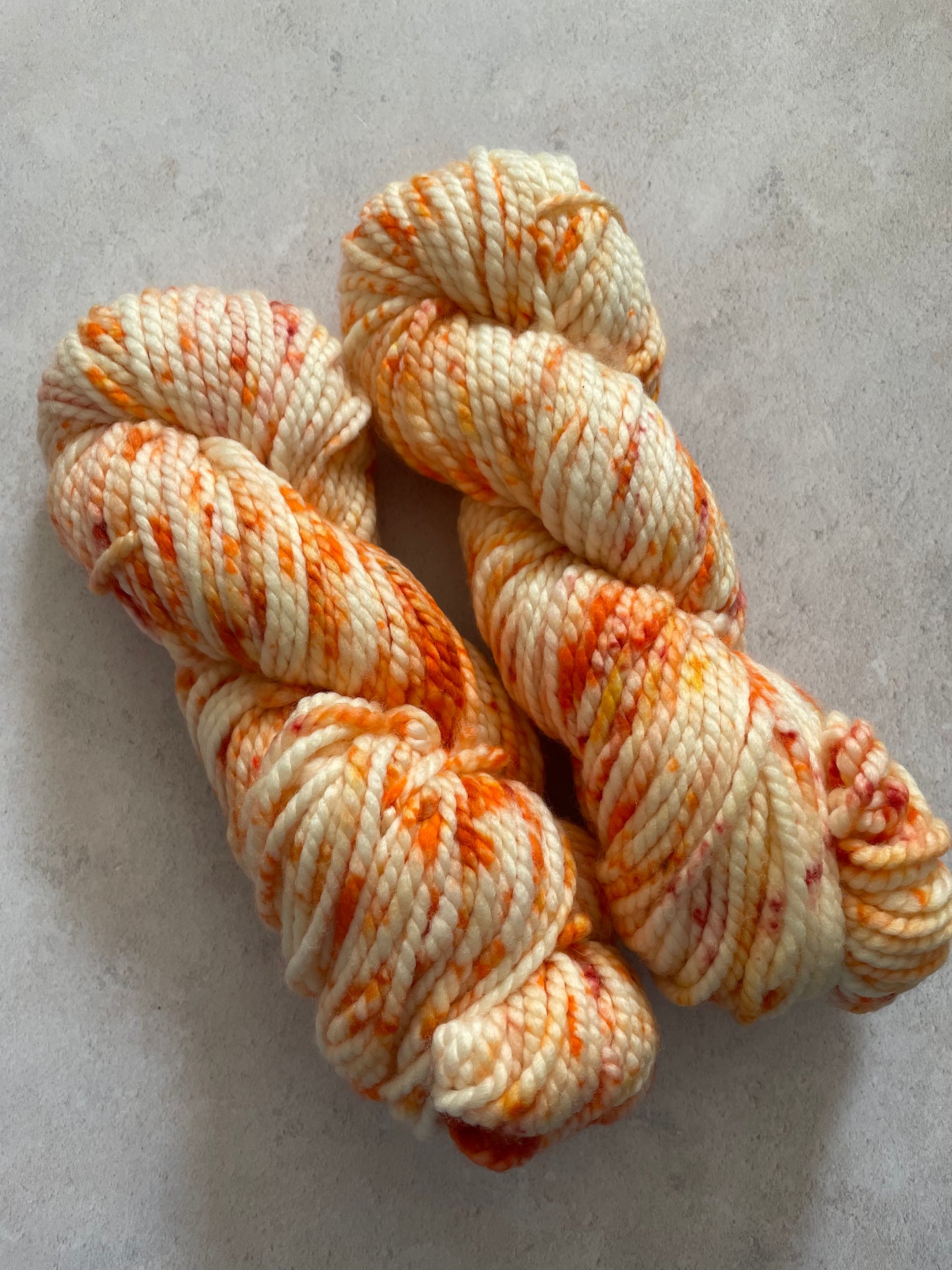 Chunky yarn skeins speckled with shades of orange