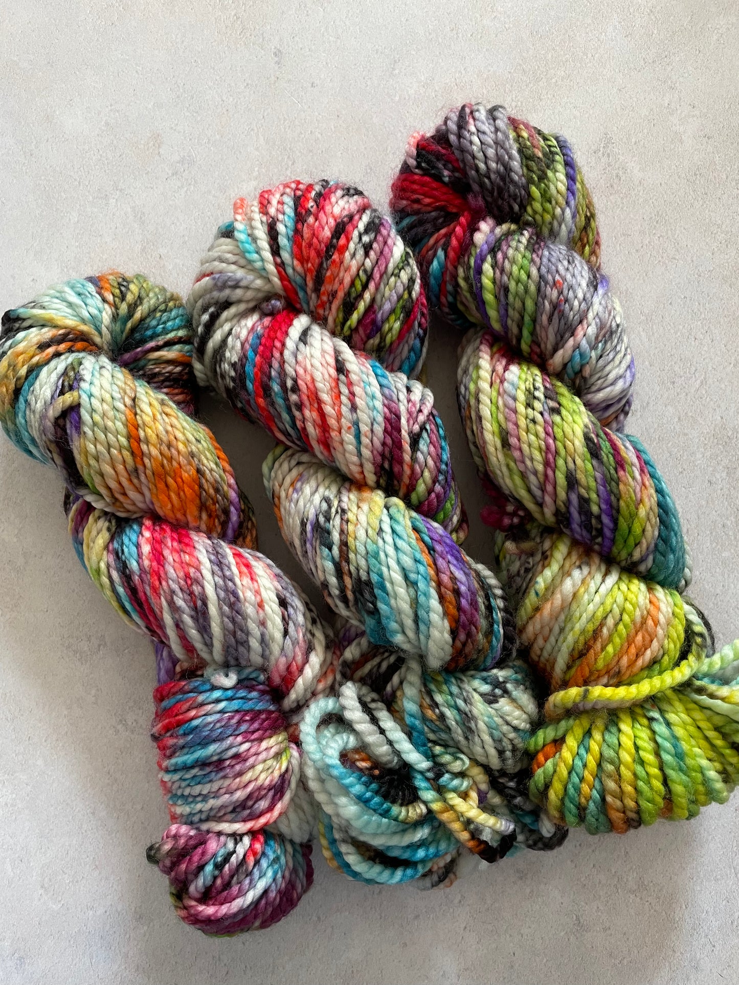 Chunky yarn skeins speckled with different colours and black