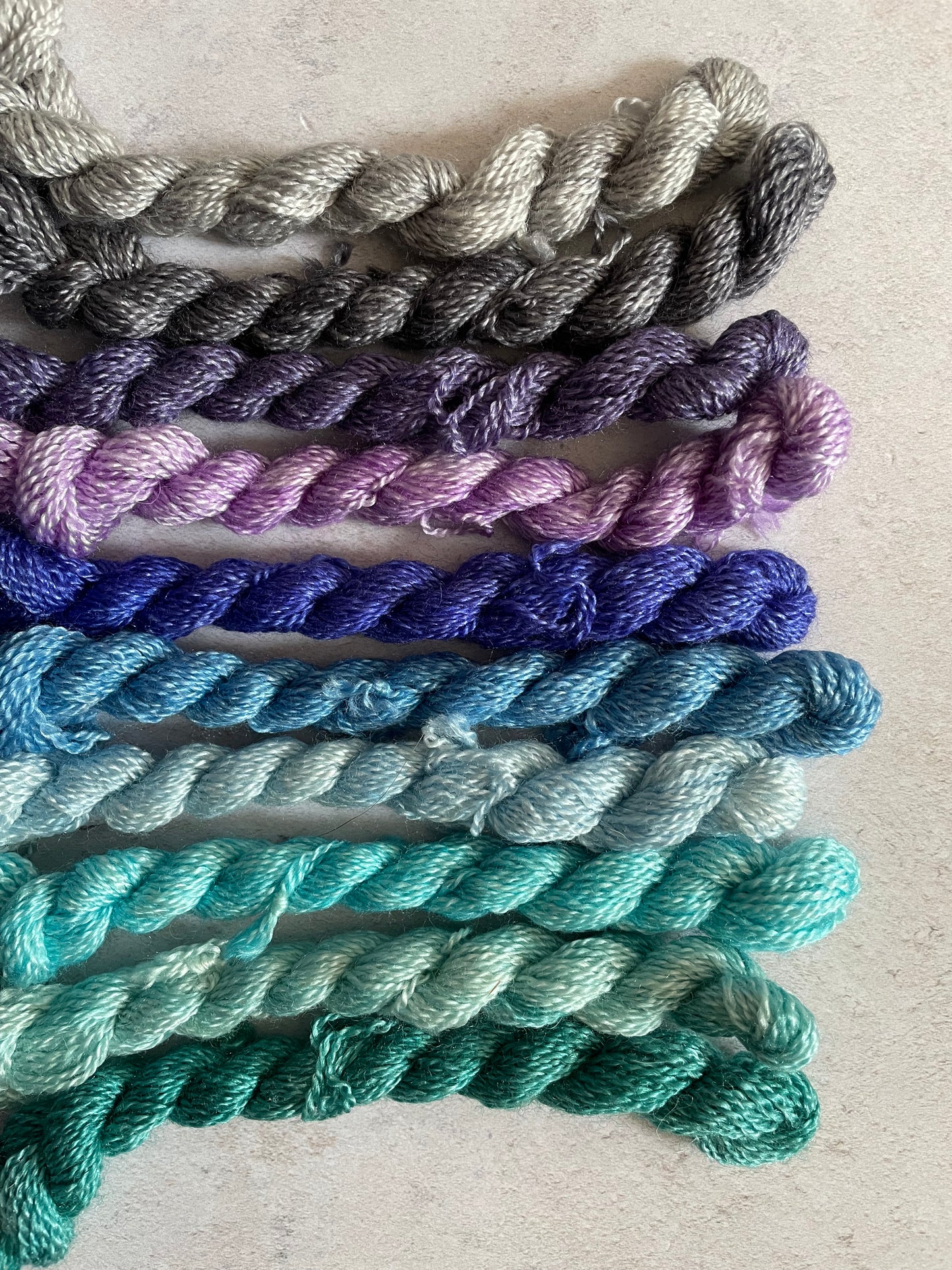 Bundle of embroidery threads in greys purples blues and teals