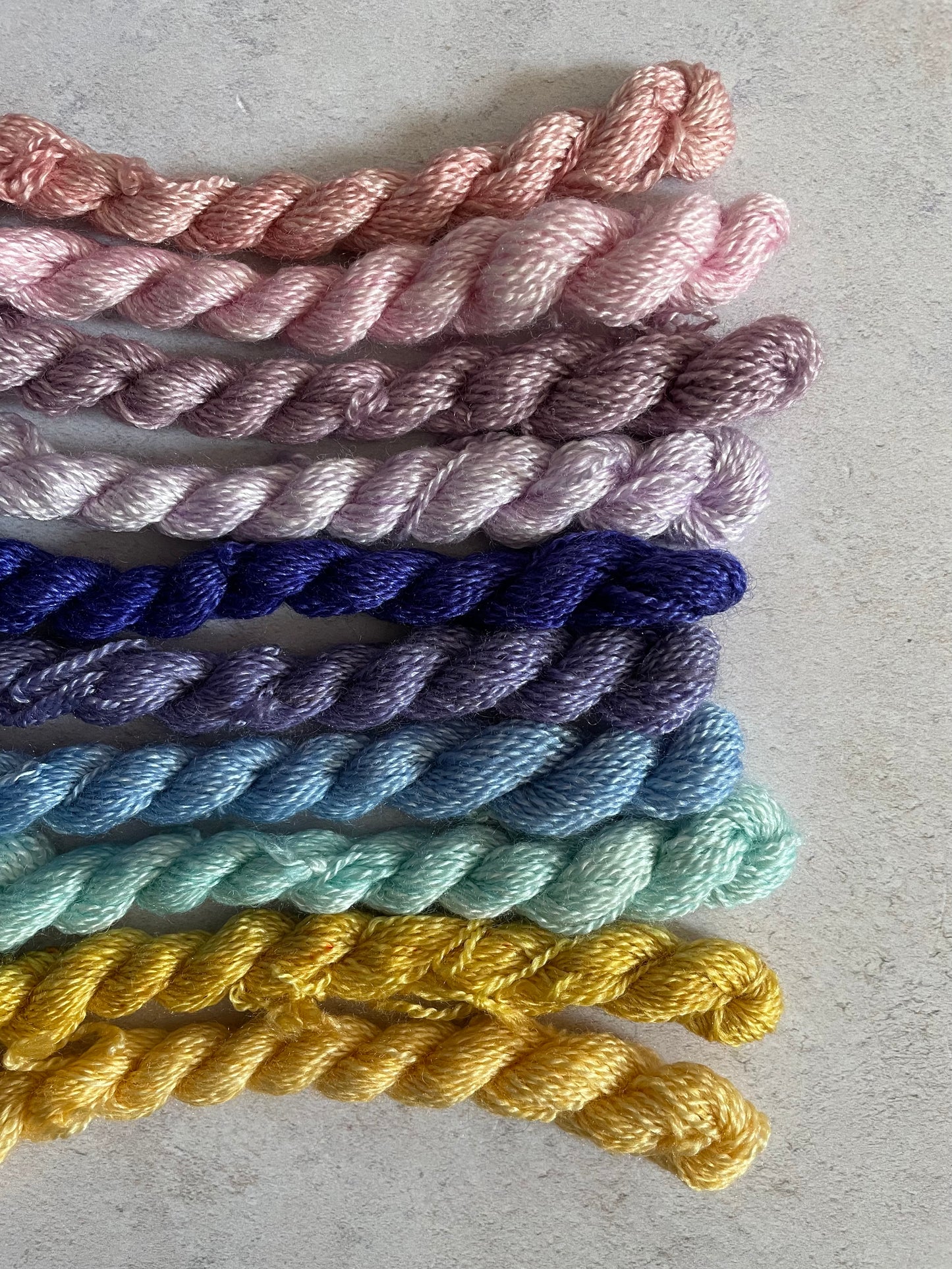 Bunlde of embroidery threads in pinks purples blues and yellows