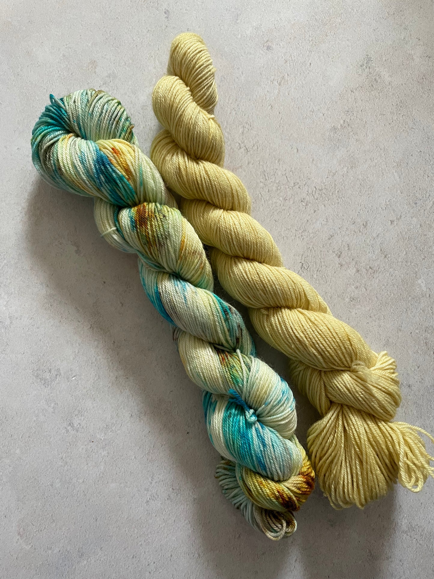 One 50g variegated blue and gold skein and one 50g pale gold skein