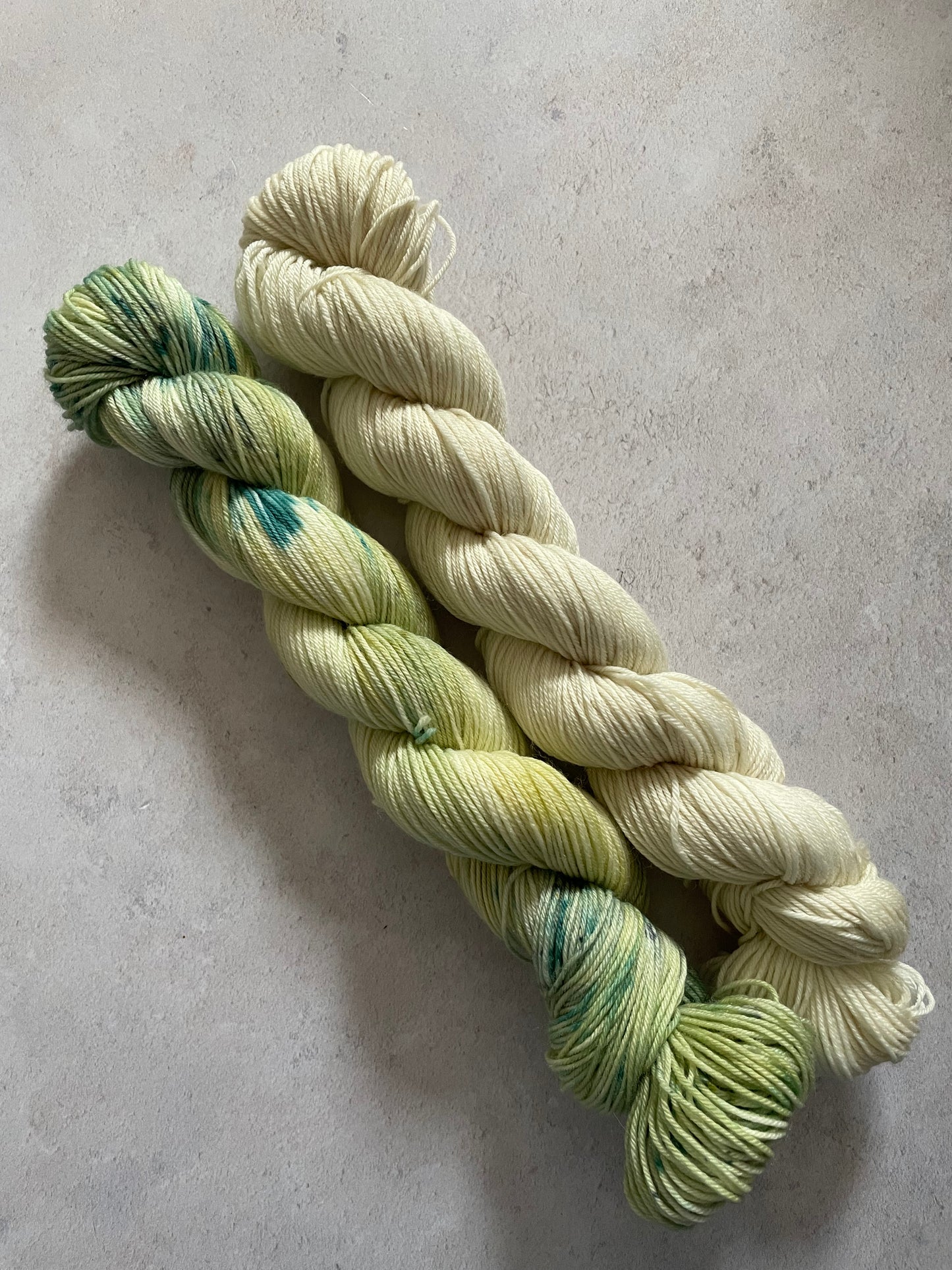 One 50g variegated pale green skein and one 50g cream skein