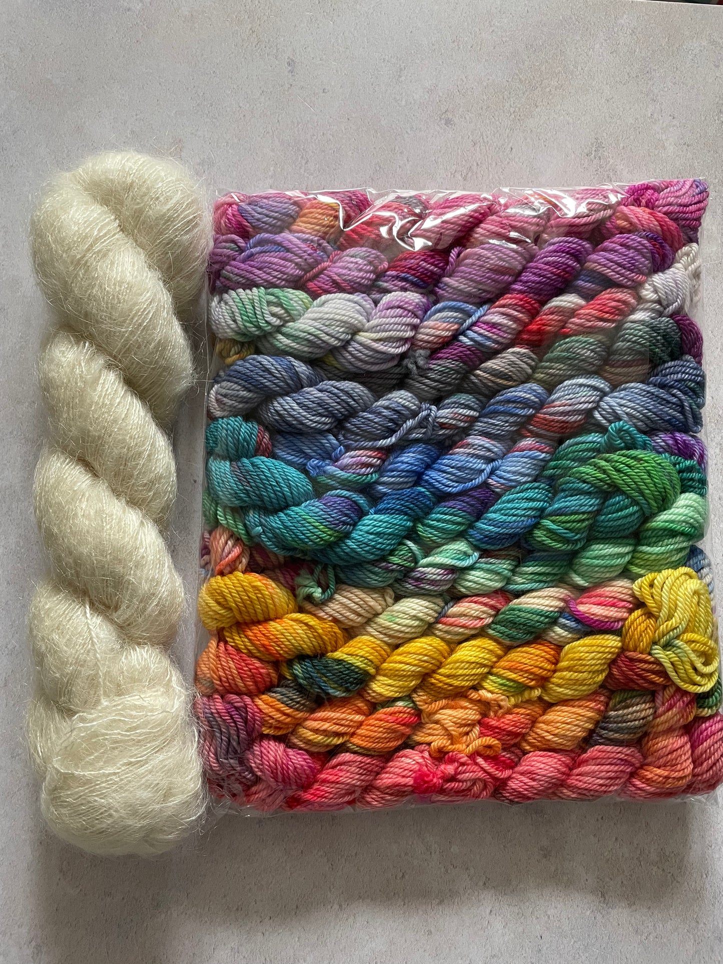 Skein of cream fluff yarn and 12 10g double knitting weight minis