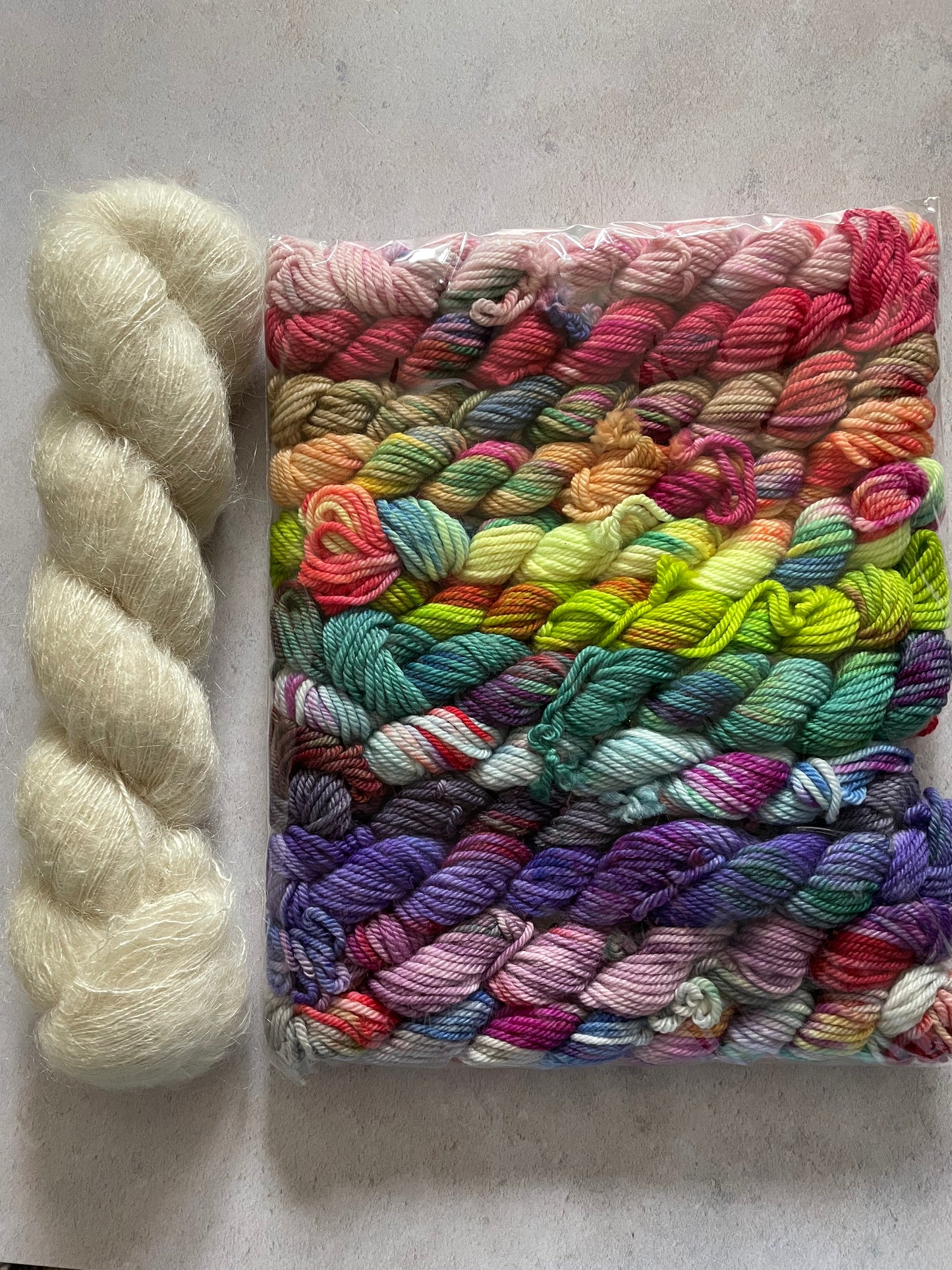 Skein of cream fluff yarn and 12 10g double knitting weight minis