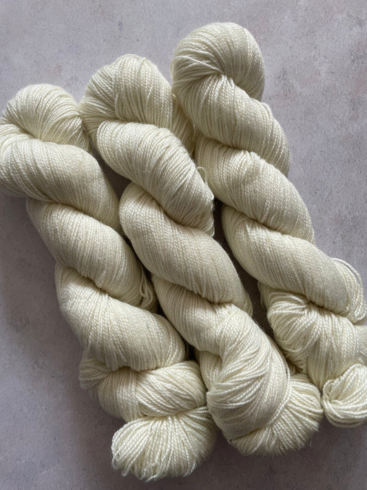 Three skeins of undyed silver sparkle sock