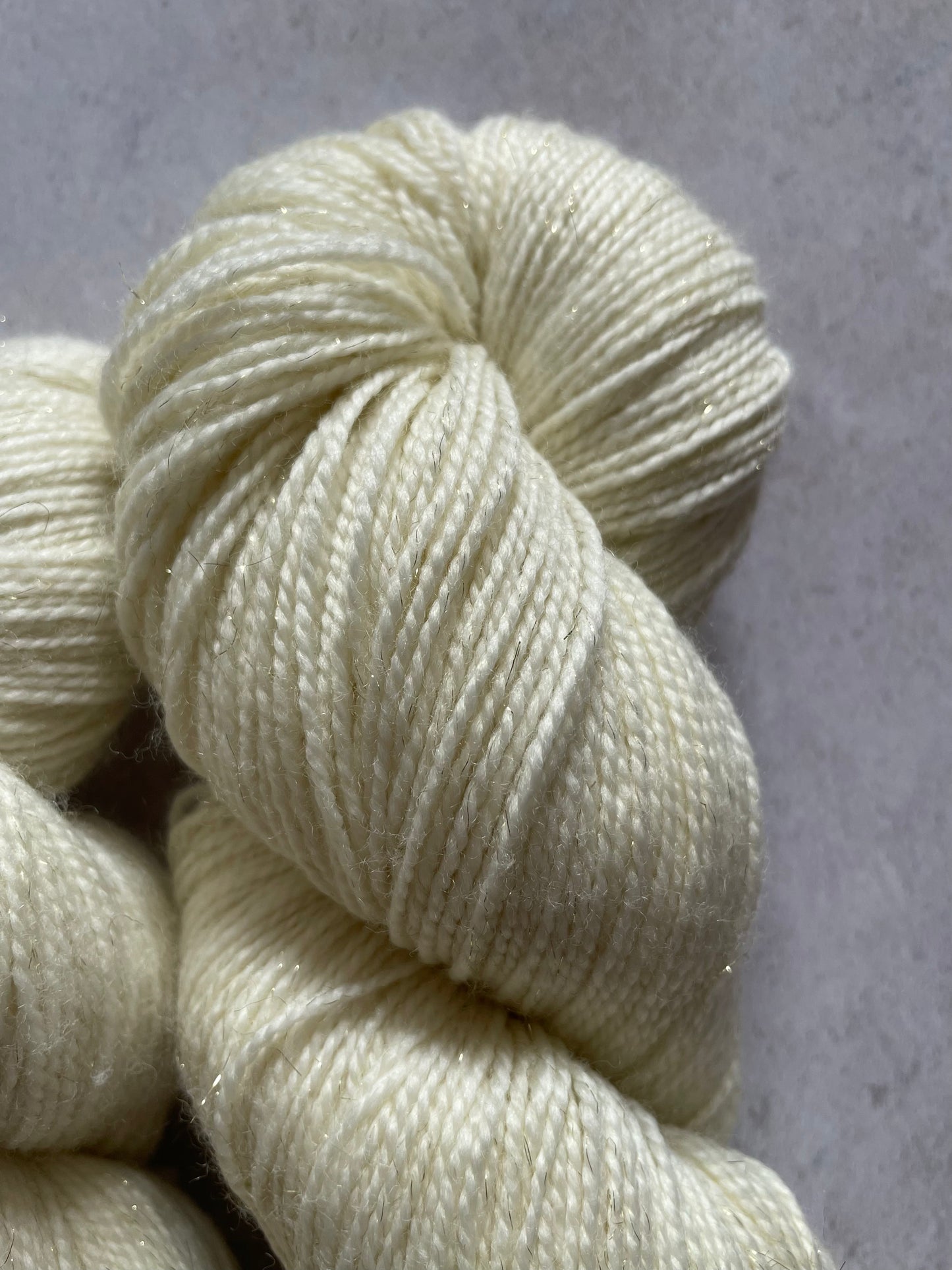 A close up of undyed gold sparkle sock