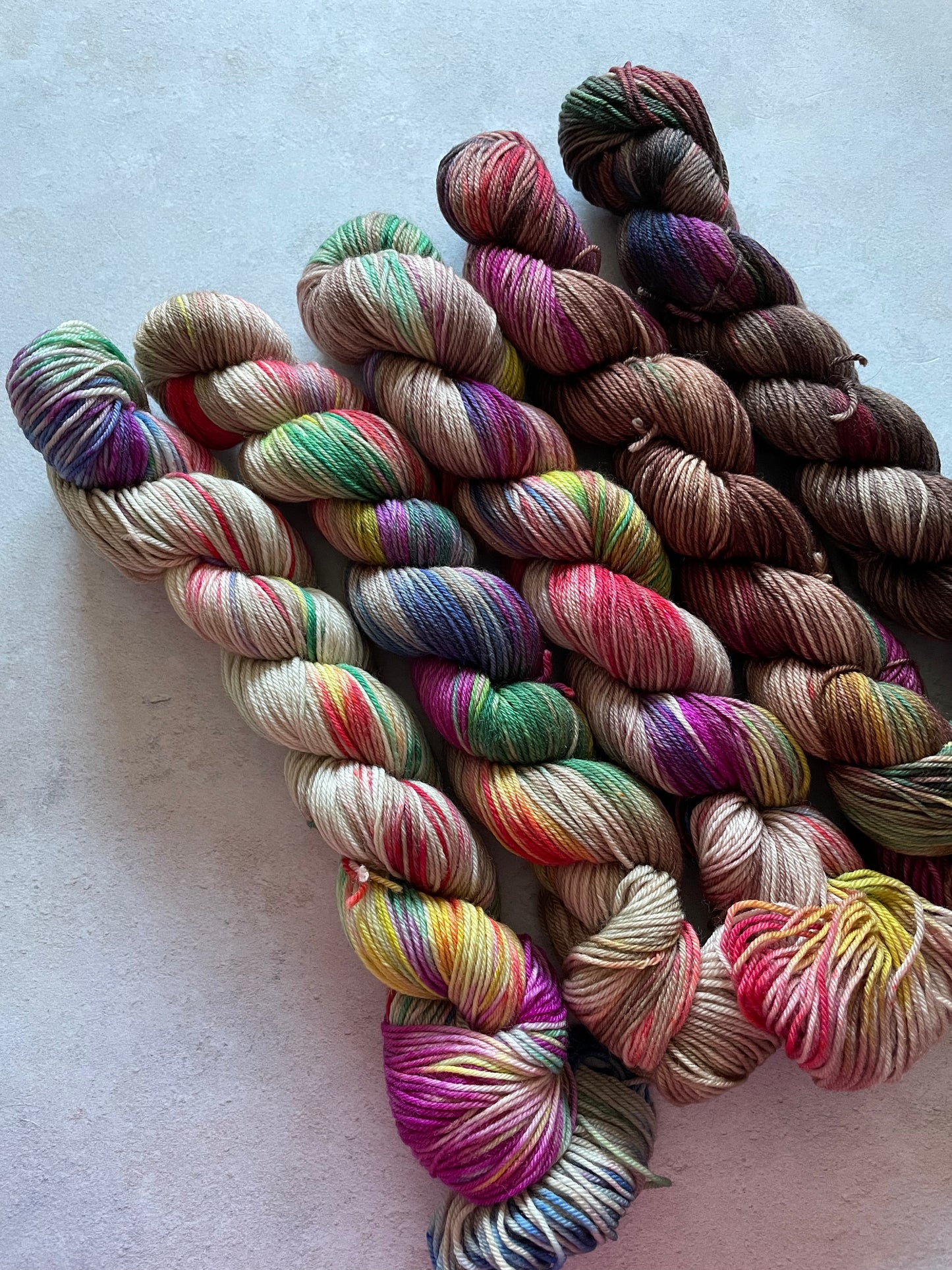 5 skeins of multicoloured and brown yarn in different shades