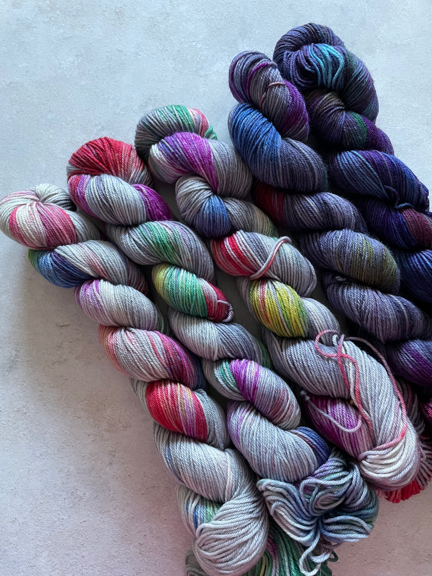 5 skeins of multicoloured and indigo blue yarn in different shades