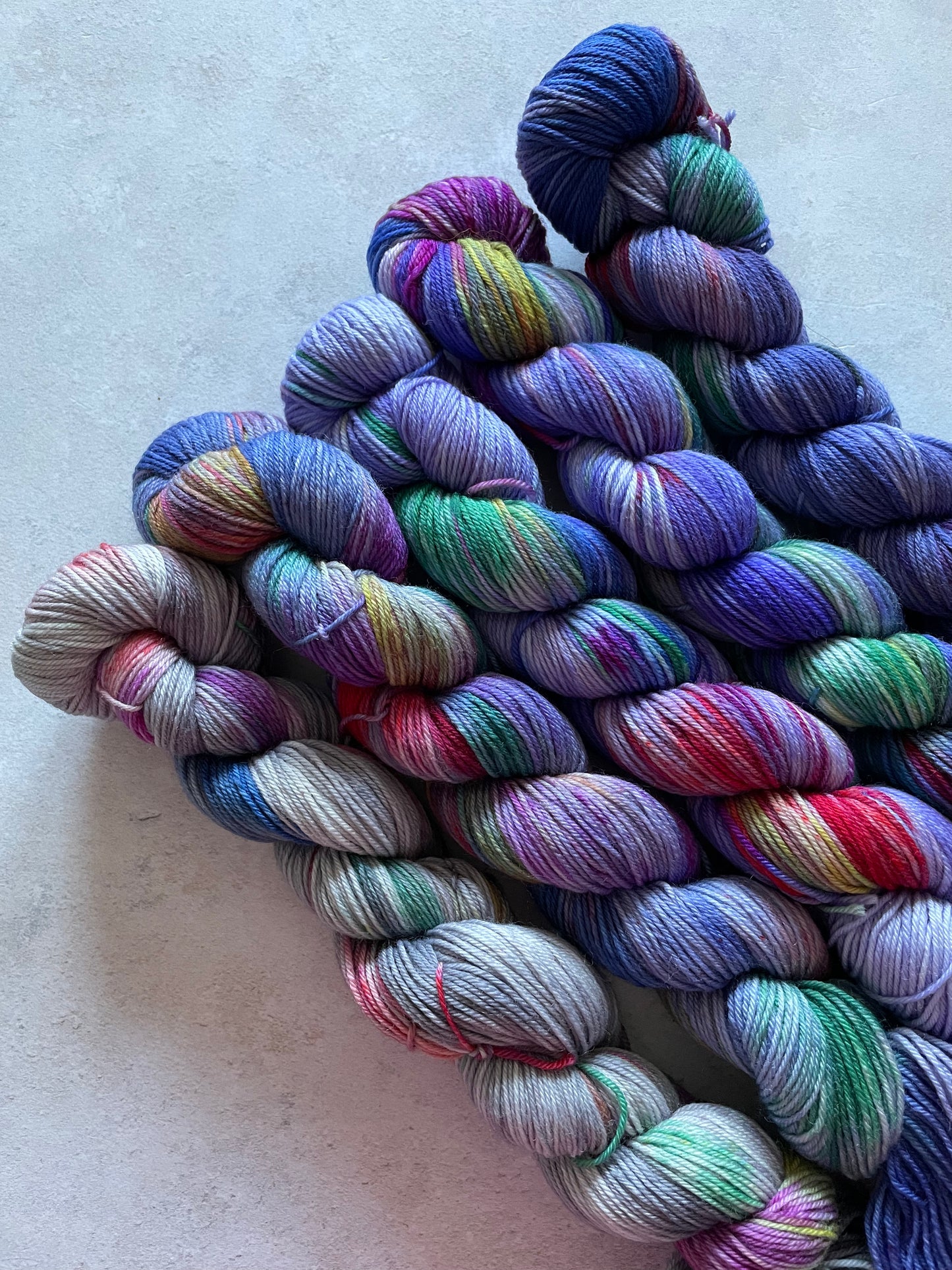 5 skeins of multicoloured and violet yarn in different shades