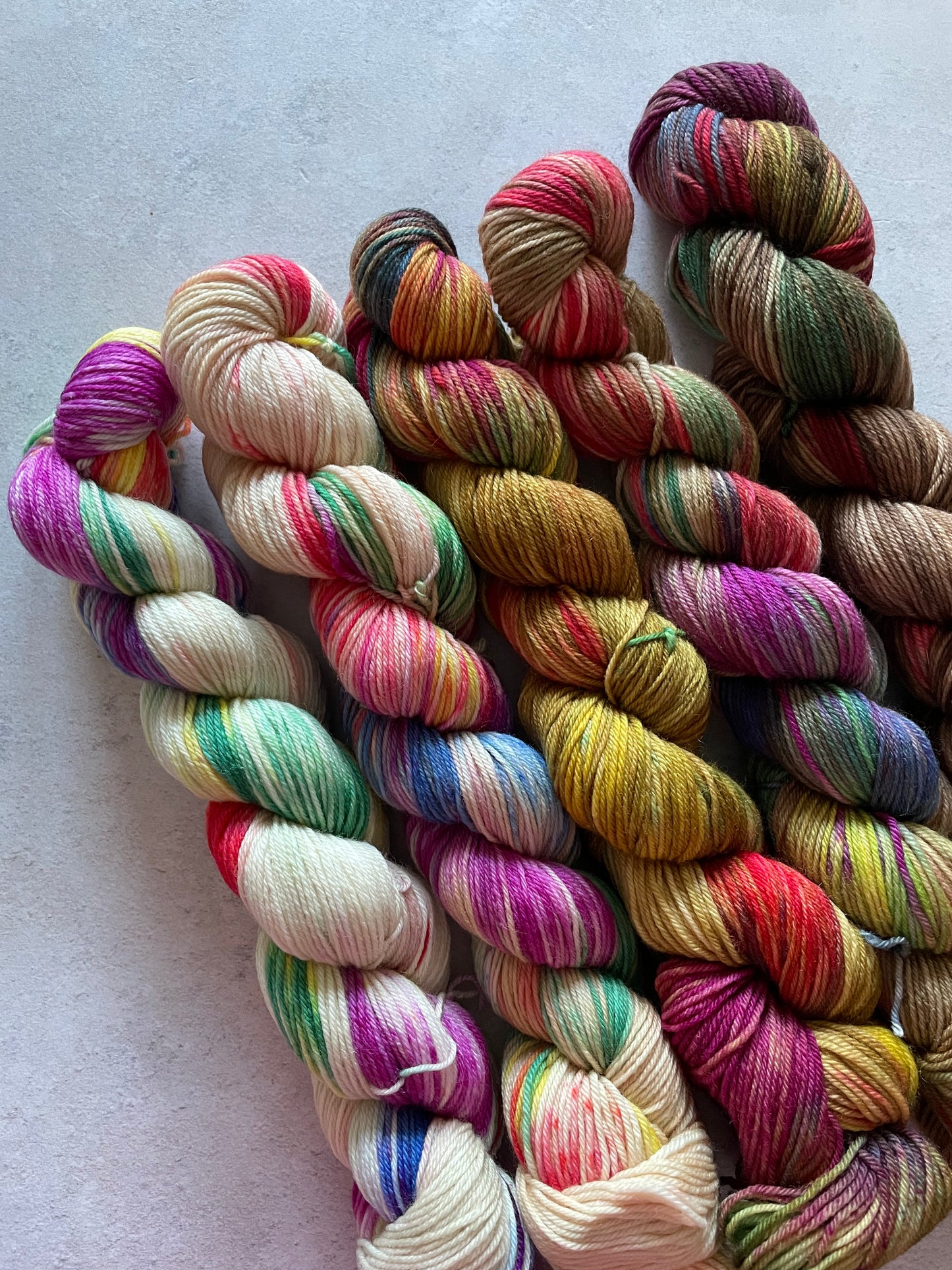 5 skeins of multicoloured and cream or brown yarn in different shades