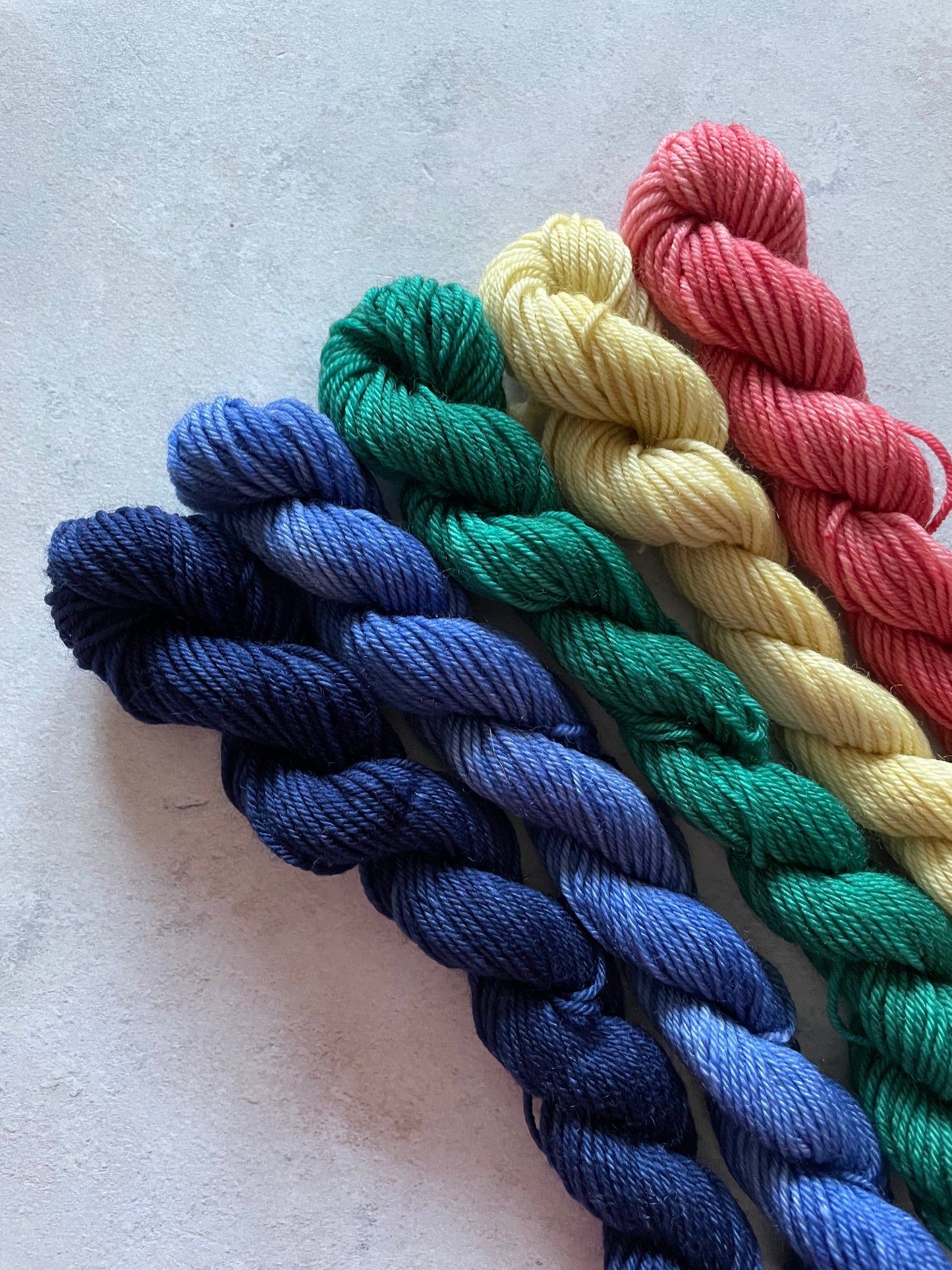 5 mini skeins in shades of blue green yellow and red