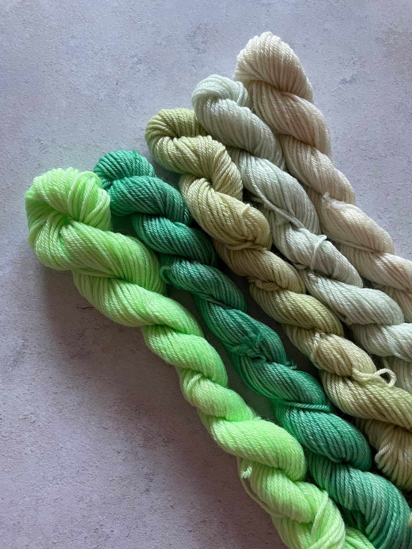 5 mini skeins in shades of green and cream