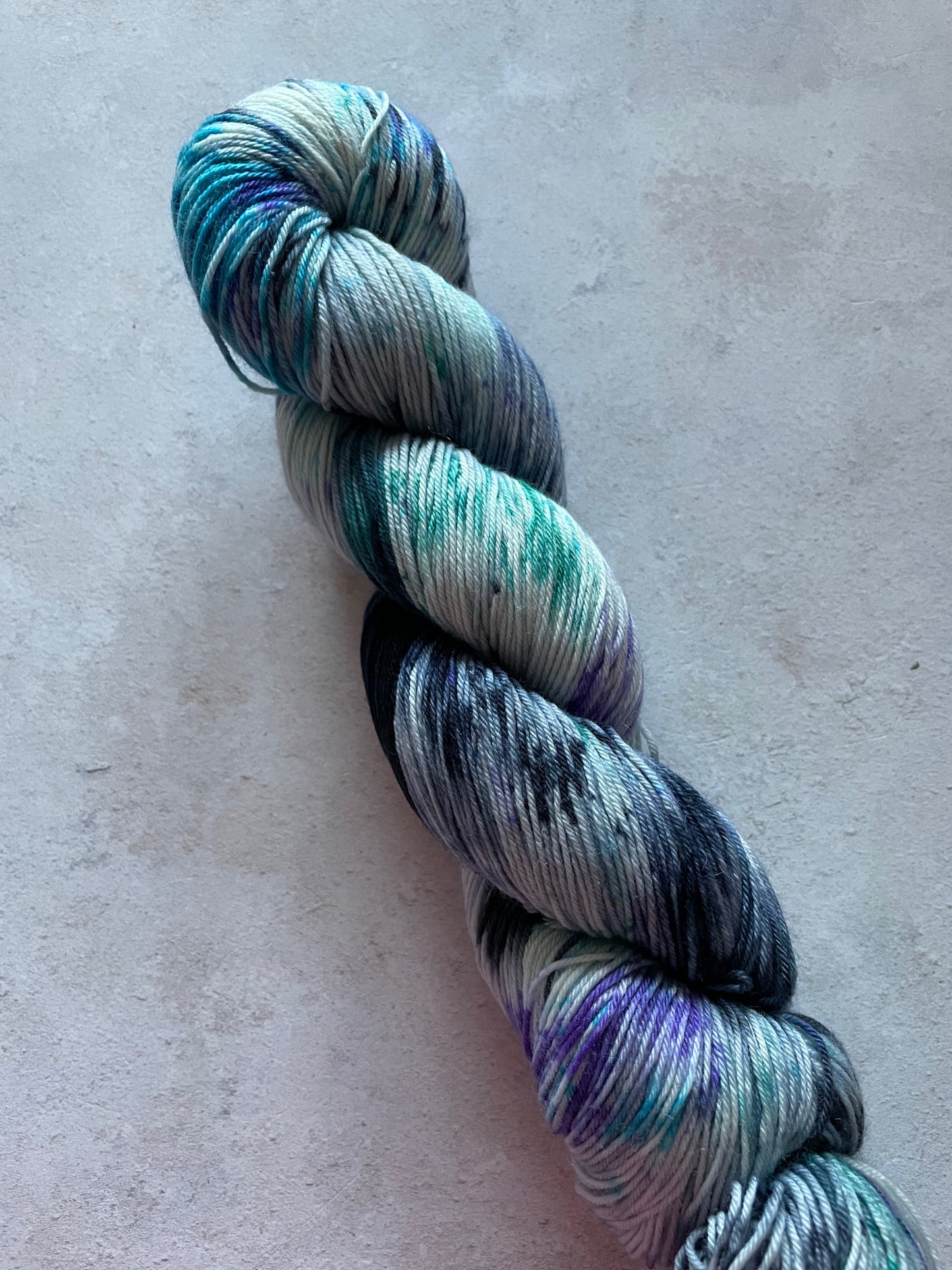 Skein of yarn with blue, teal, navy and violet