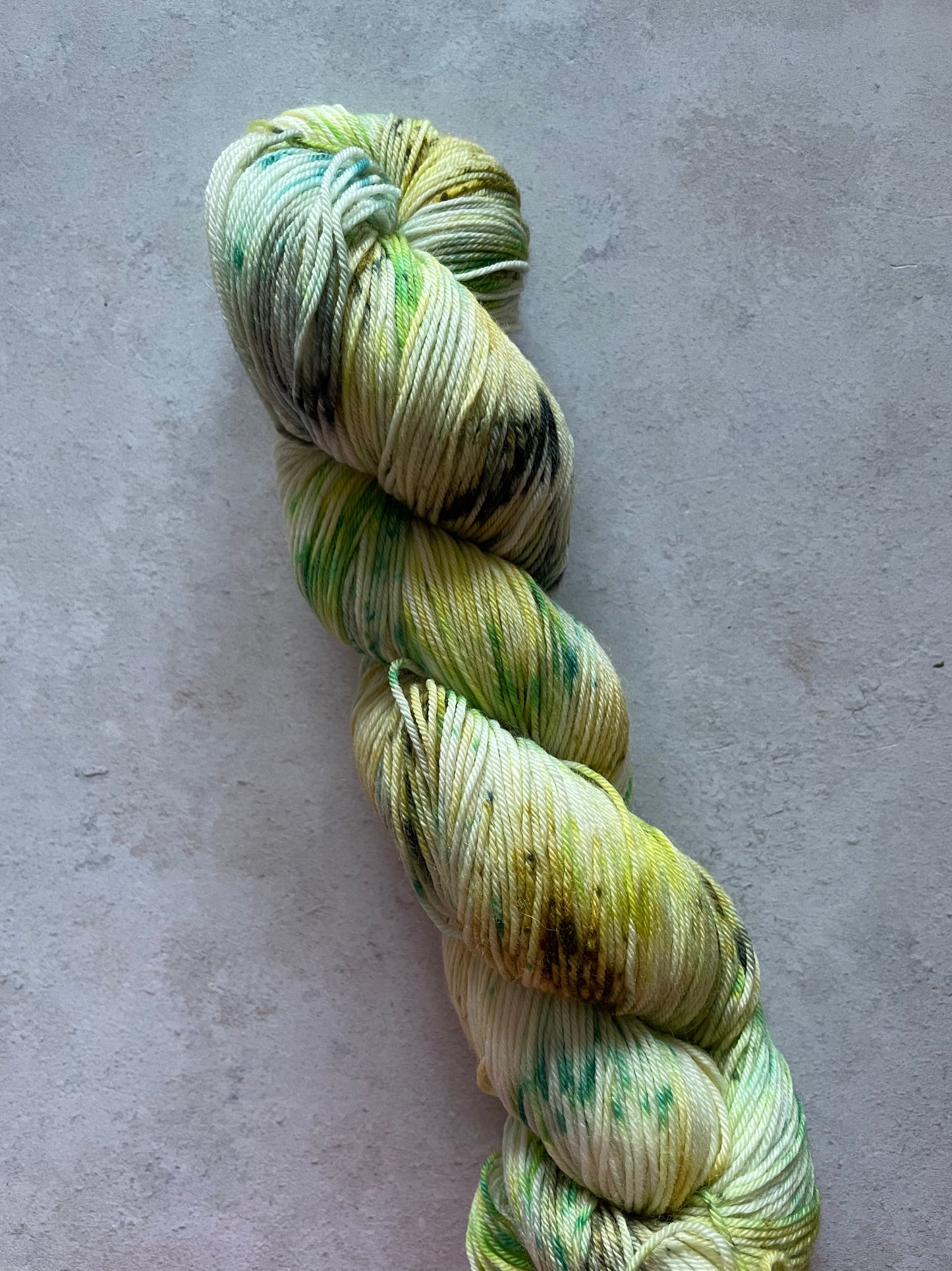 Skein of yarn speckled with shades of greens