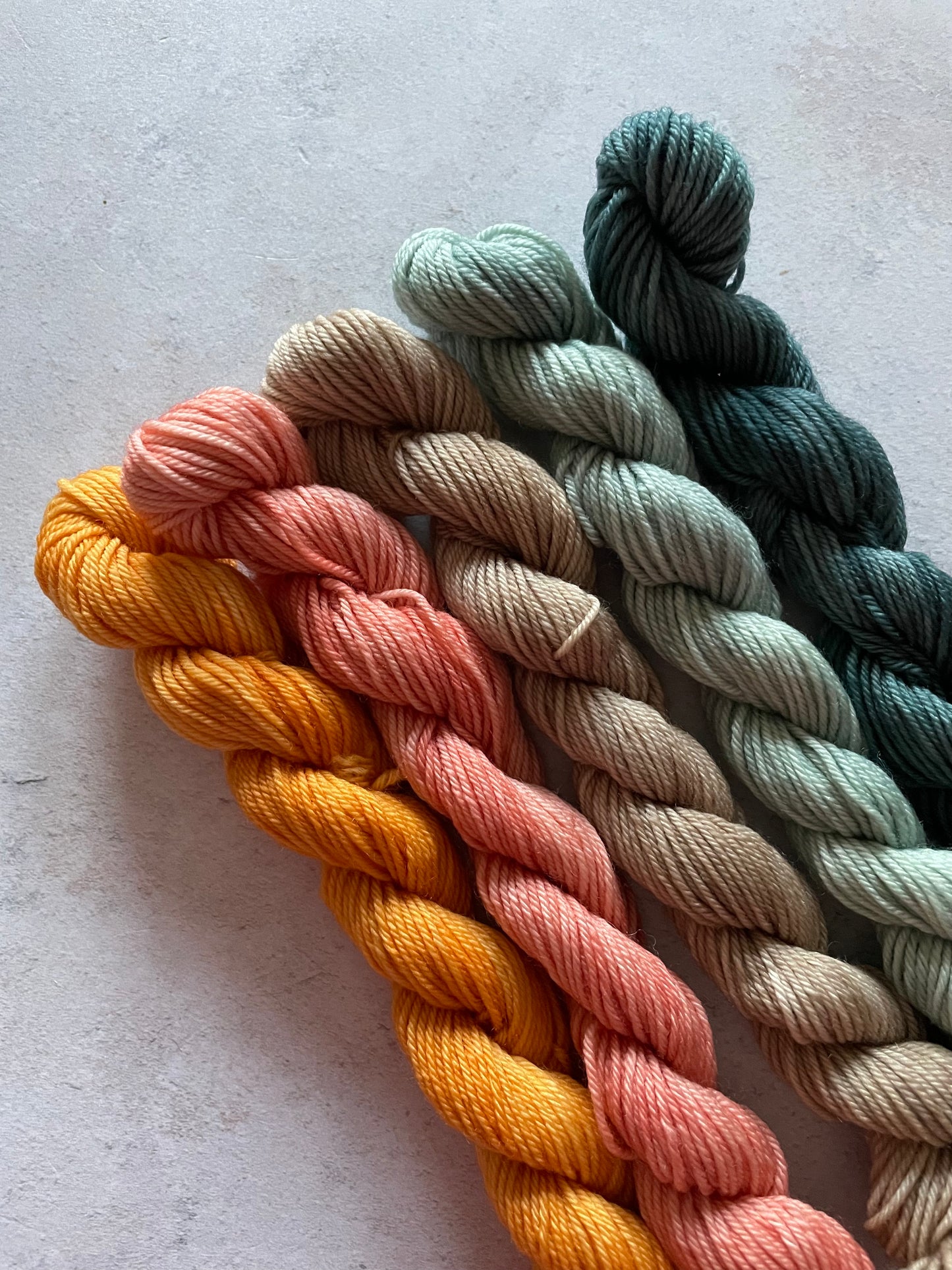 5 mini skeins in shades of orange beige and grey green