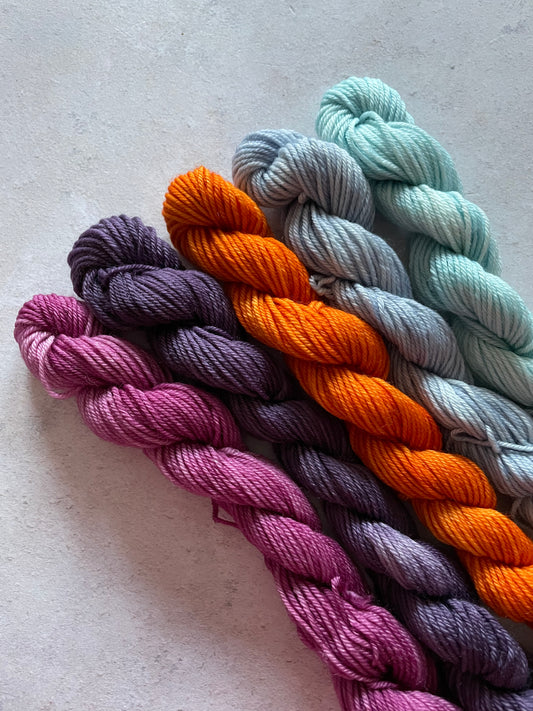 5 mini skeins in shades of purple orange and light blue