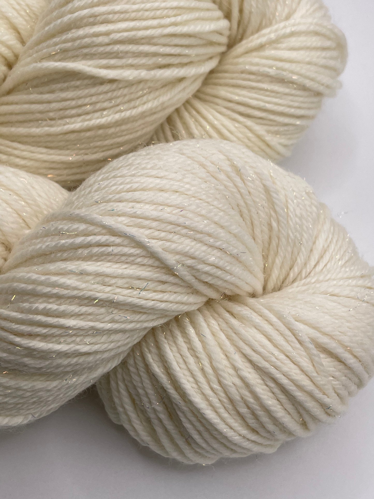 Skeins of undyed merino nylon sock yarn with iridescent stellina