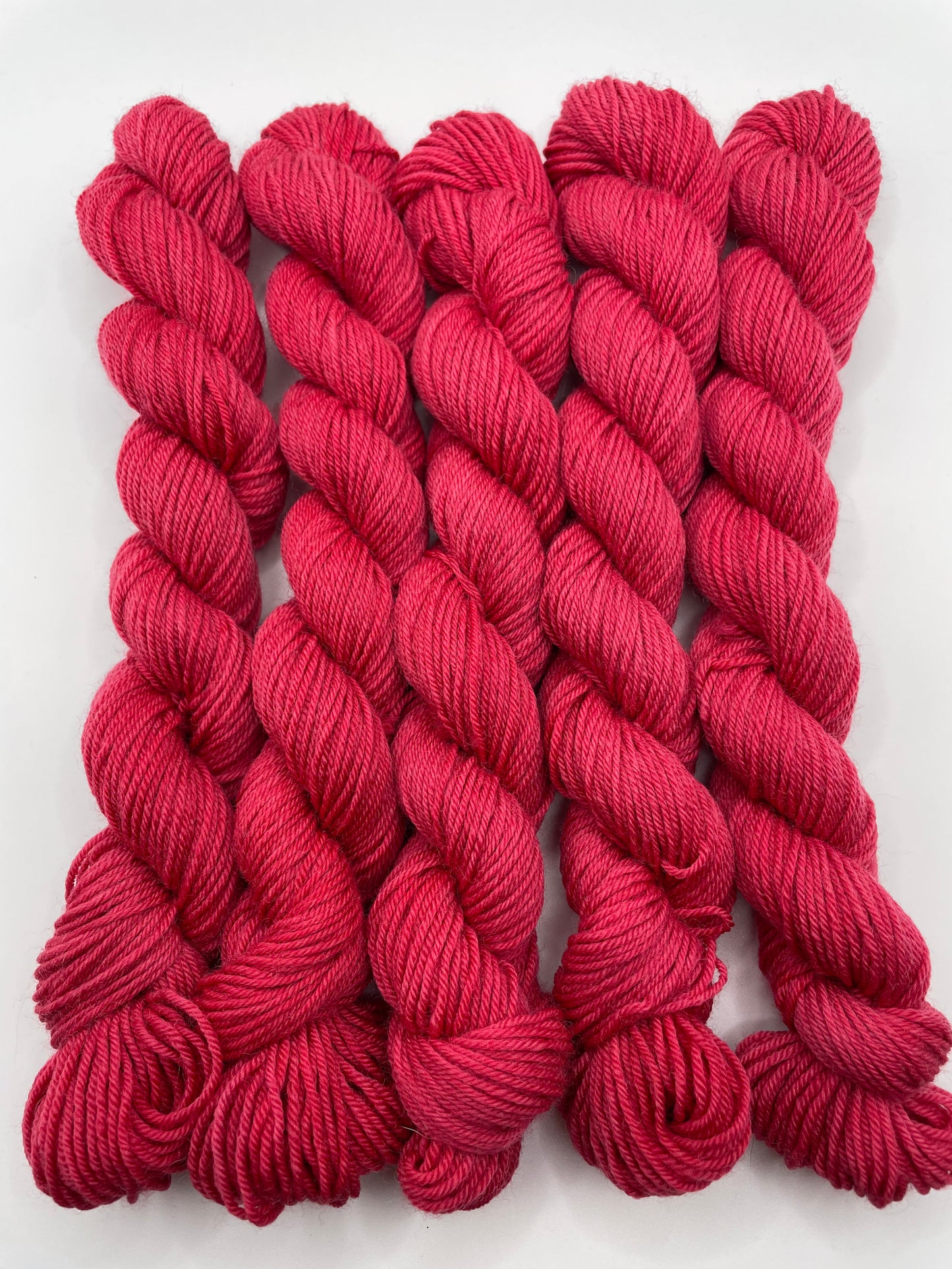 Red yarn mini skeins on a white background