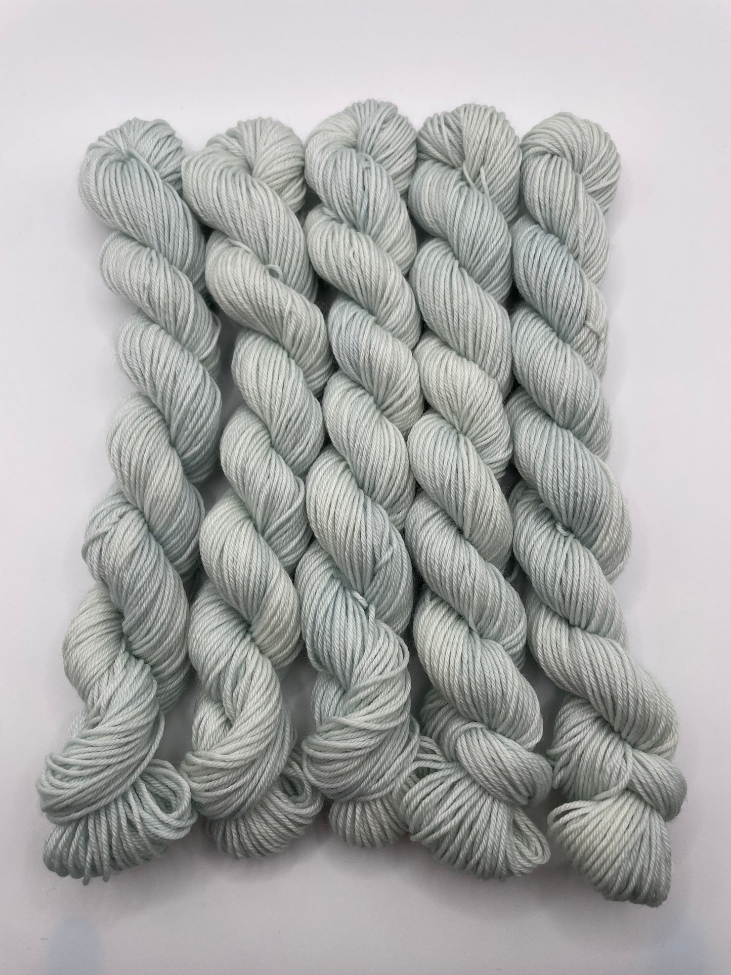 Pale mint mini skeins on a white background