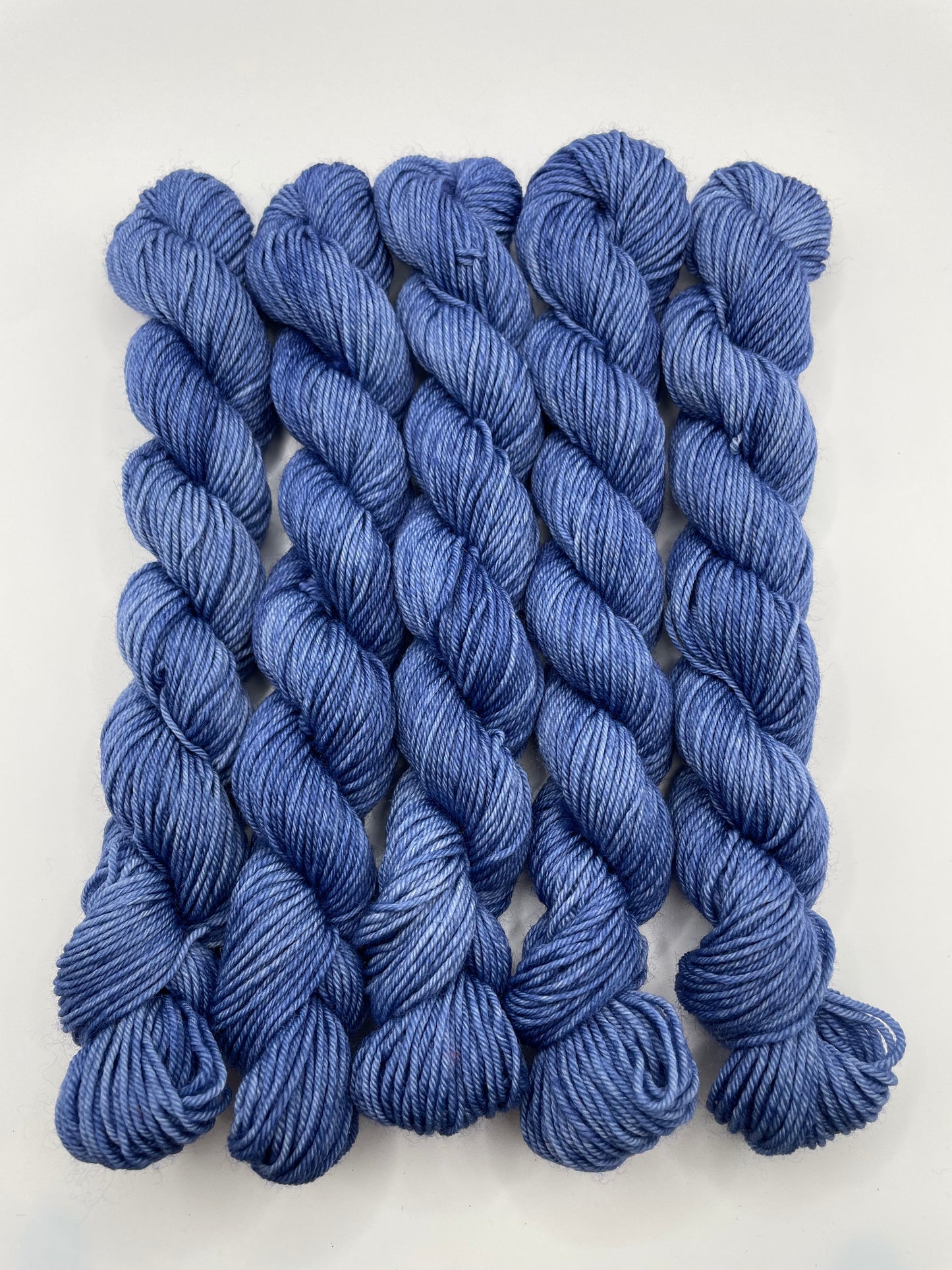 Deep blue yarn mini skeins on a white background