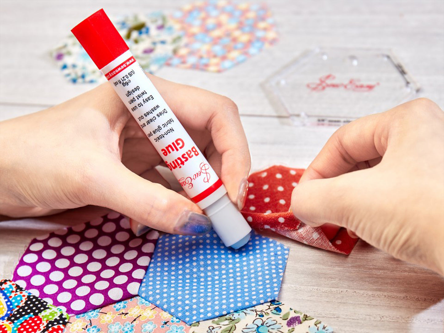 Picture of the basting glue pen being used on fabric hexagons
