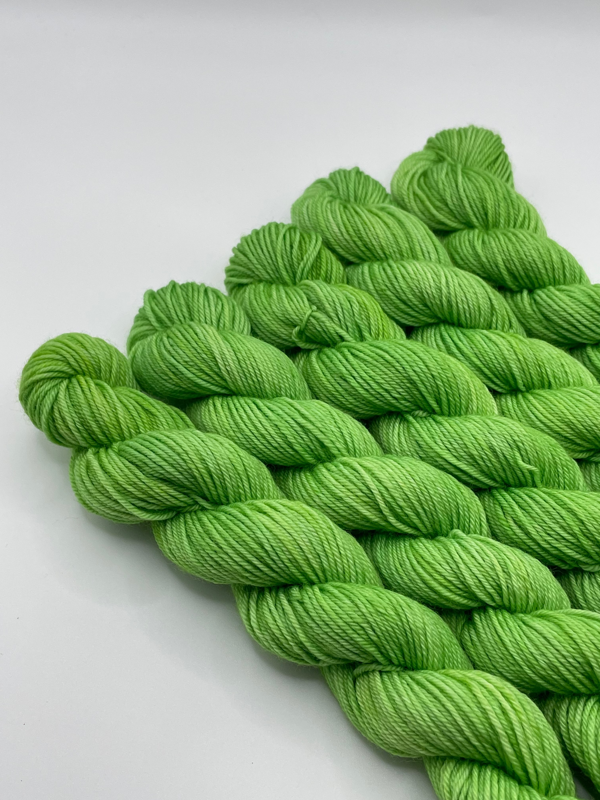 Green yarn mini skeins on a white background