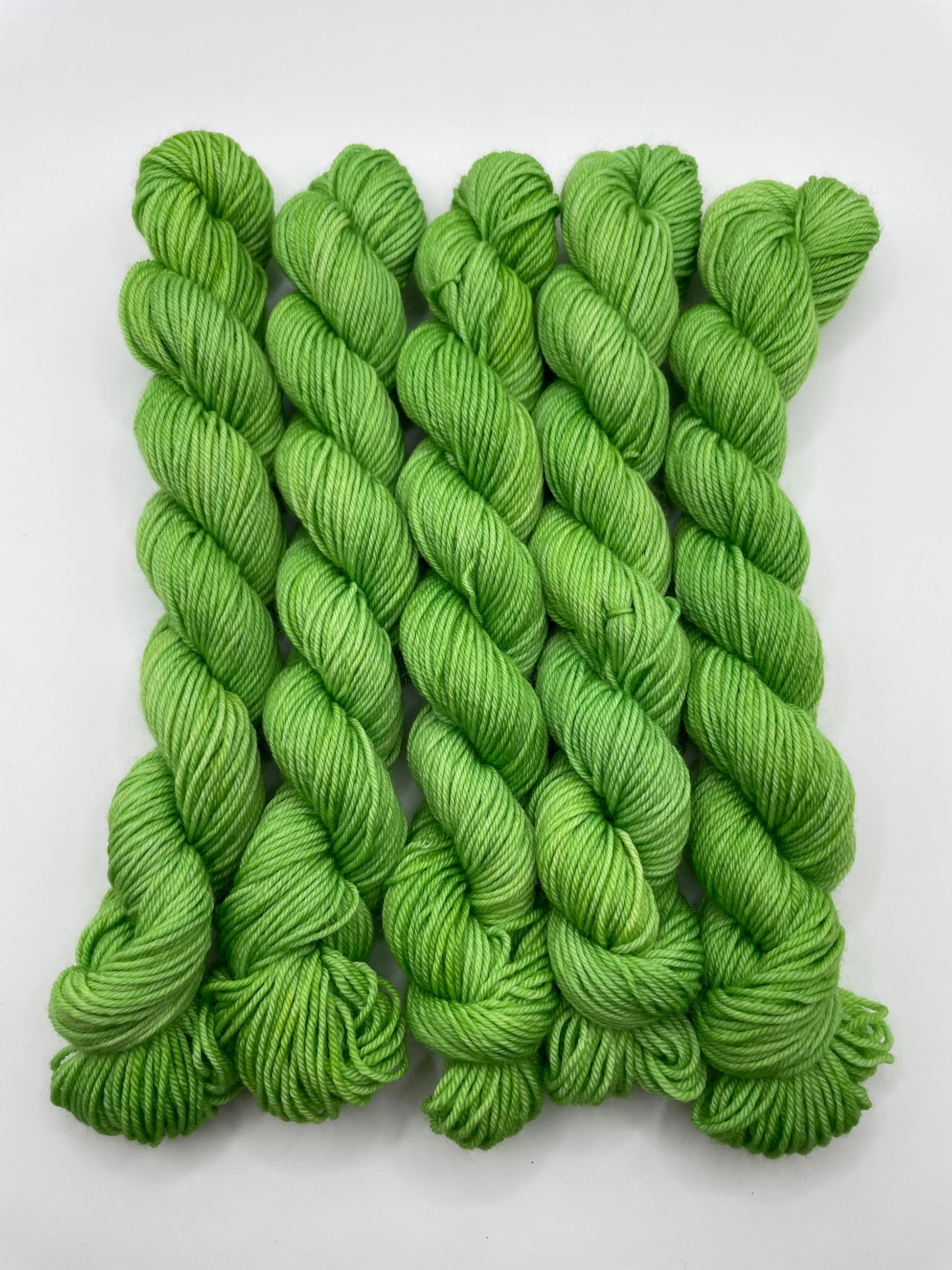 Green yarn mini skeins on a white background
