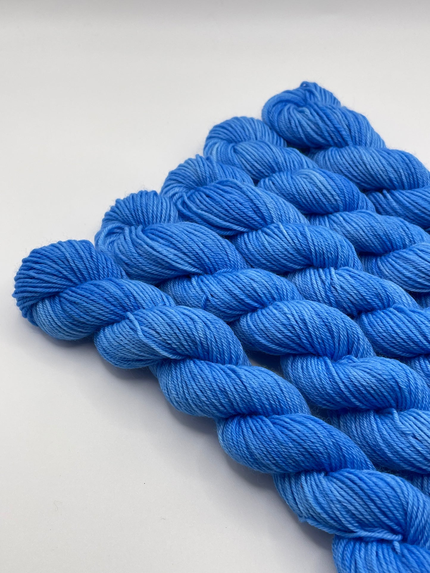 Blue yarn mini skeins on a white background