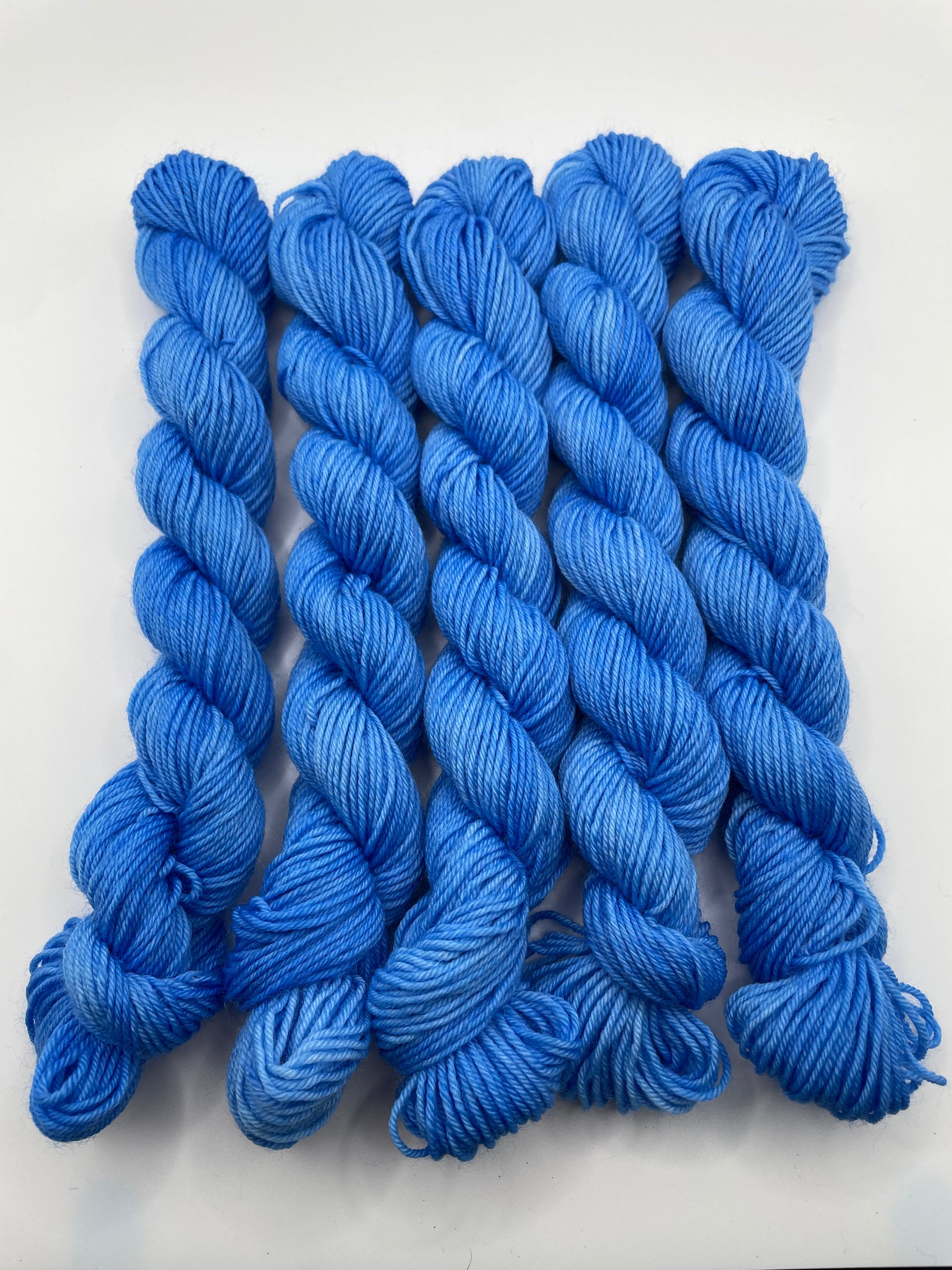Blue yarn mini skeins on a white background