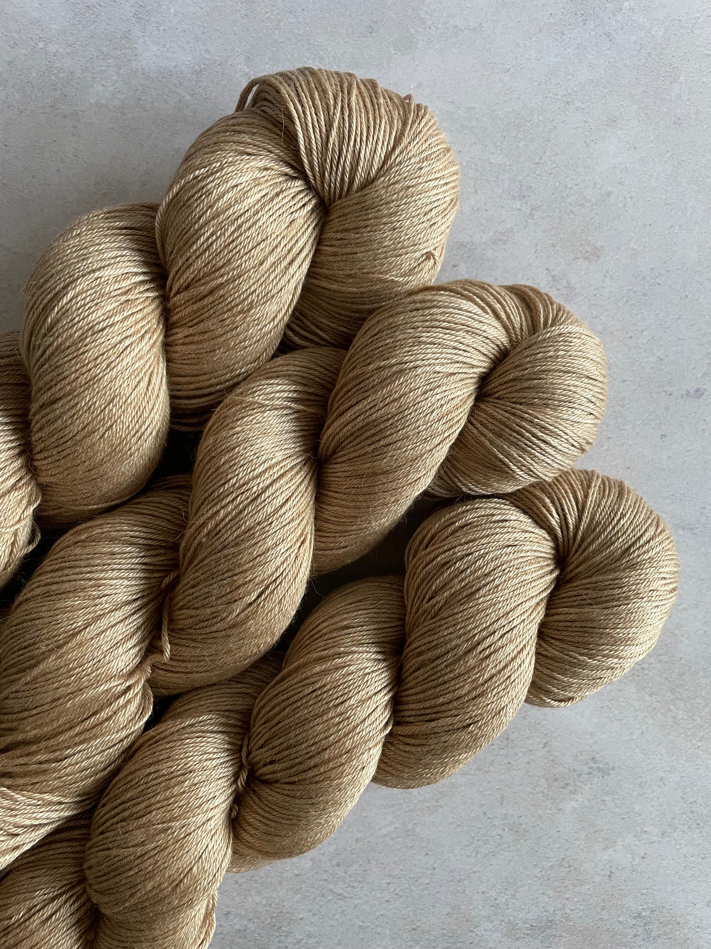 3 skeins of camel and silk 4ply weight yarn with a light warm brown tone