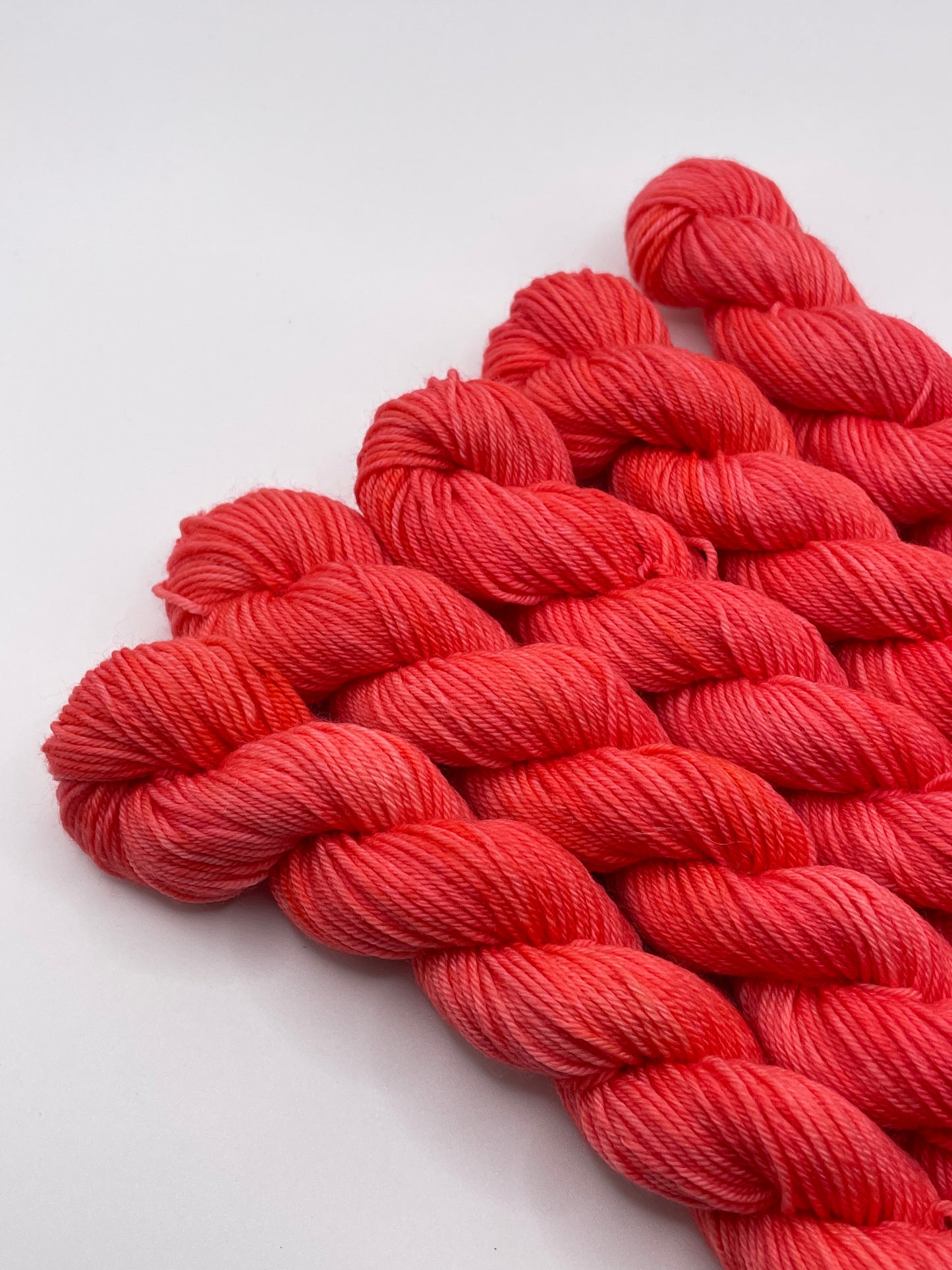 Red yarn mini skeins on a white background