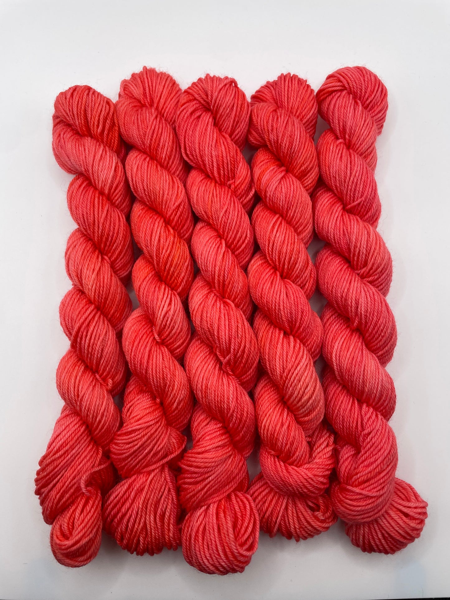 Red yarn mini skeins on a white background