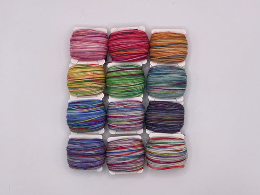 12 yarn bobbins in a pastel rainbow of colours