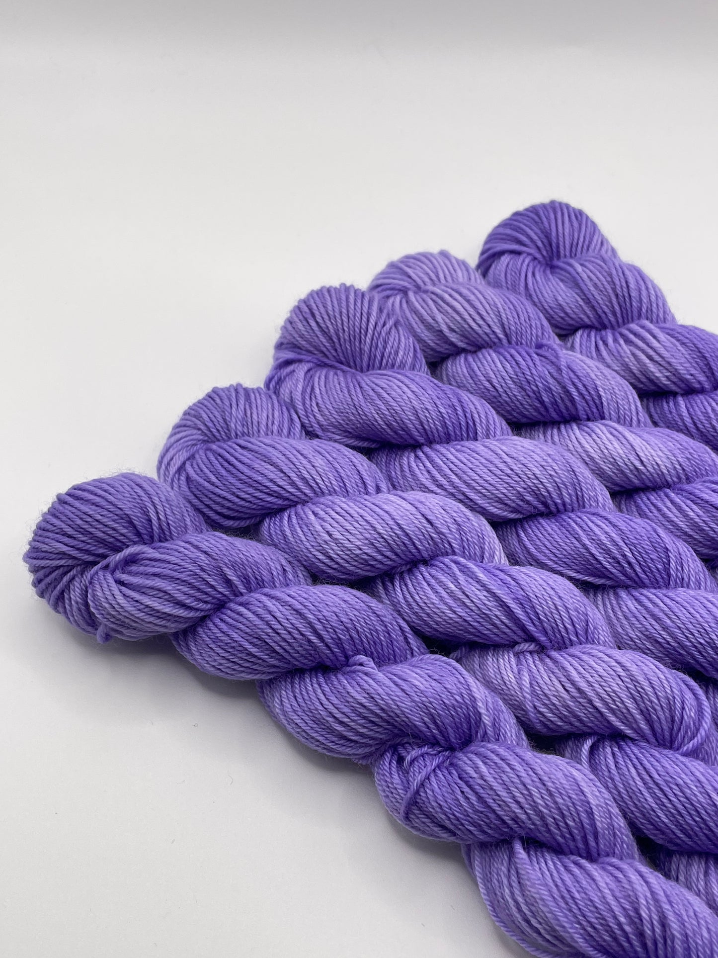 Purple yarn mini skeins on a white background