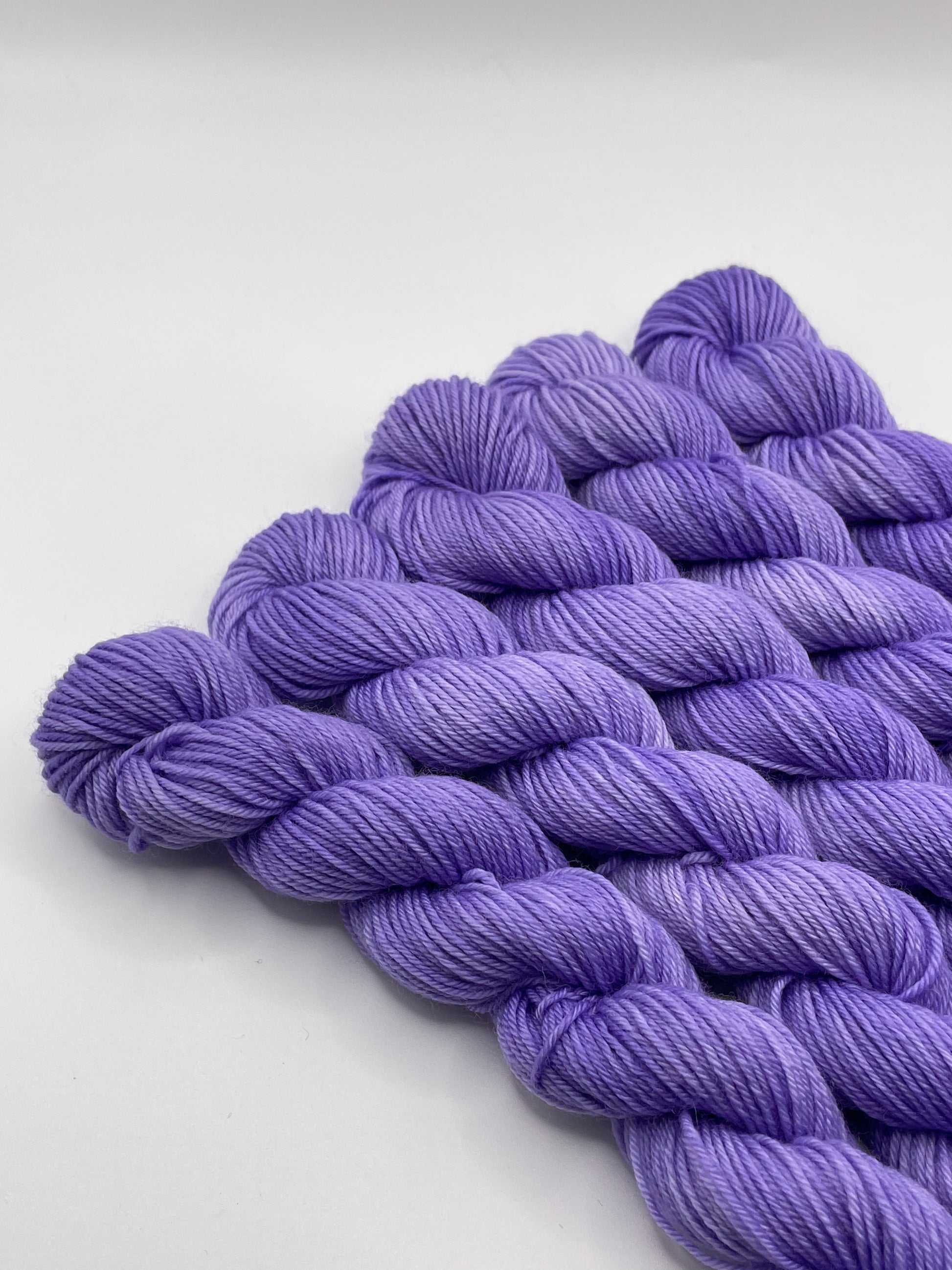 Purple yarn mini skeins on a white background