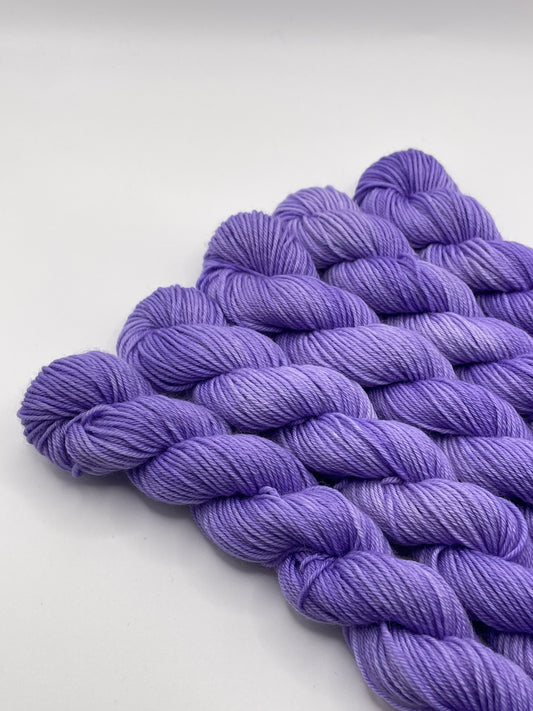 Purple yarn mini skeins on a white background