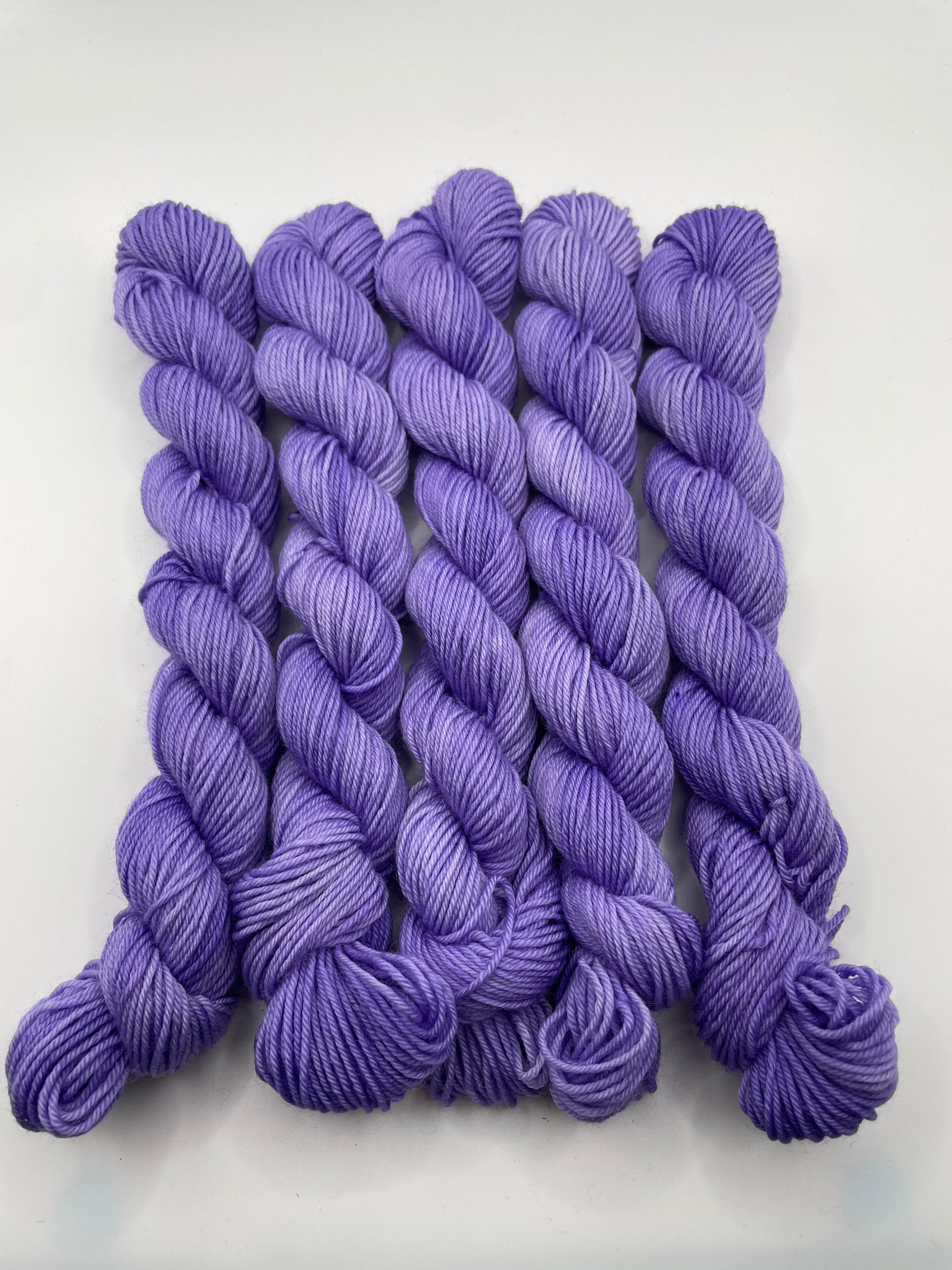 Purple yarn mini skeins on a white background