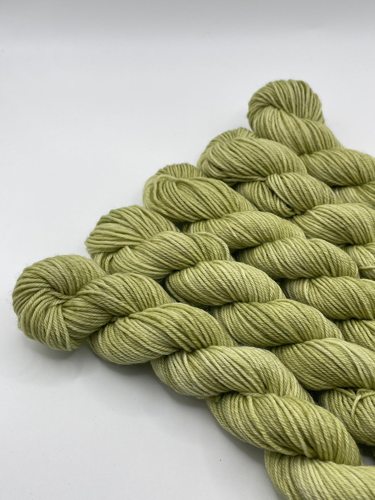 Green yarn mini skeins on a white background