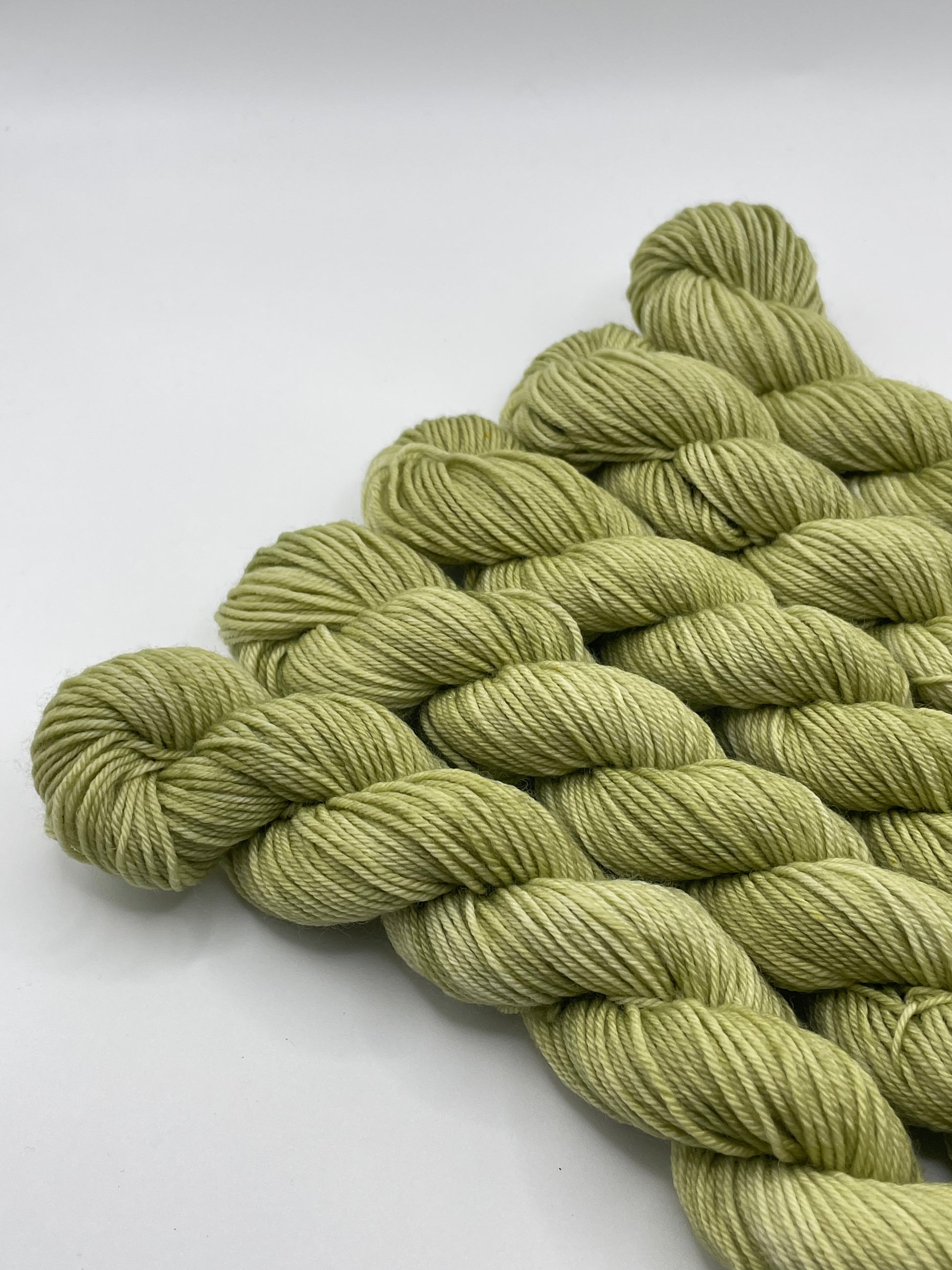 Green yarn mini skeins on a white background