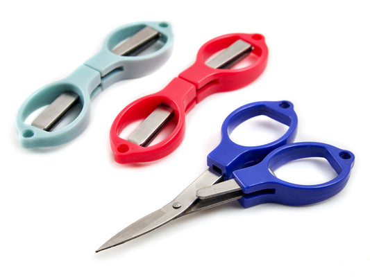 Three folding scissors in different colours on a white background - one is unfolded for using